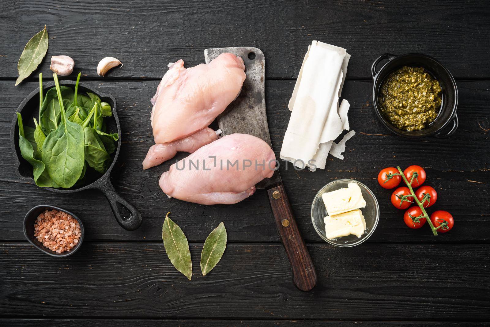 Raw Chicken meat stuffed ingredients with filo, herbs, butter set, on black wooden table background, top view flat lay