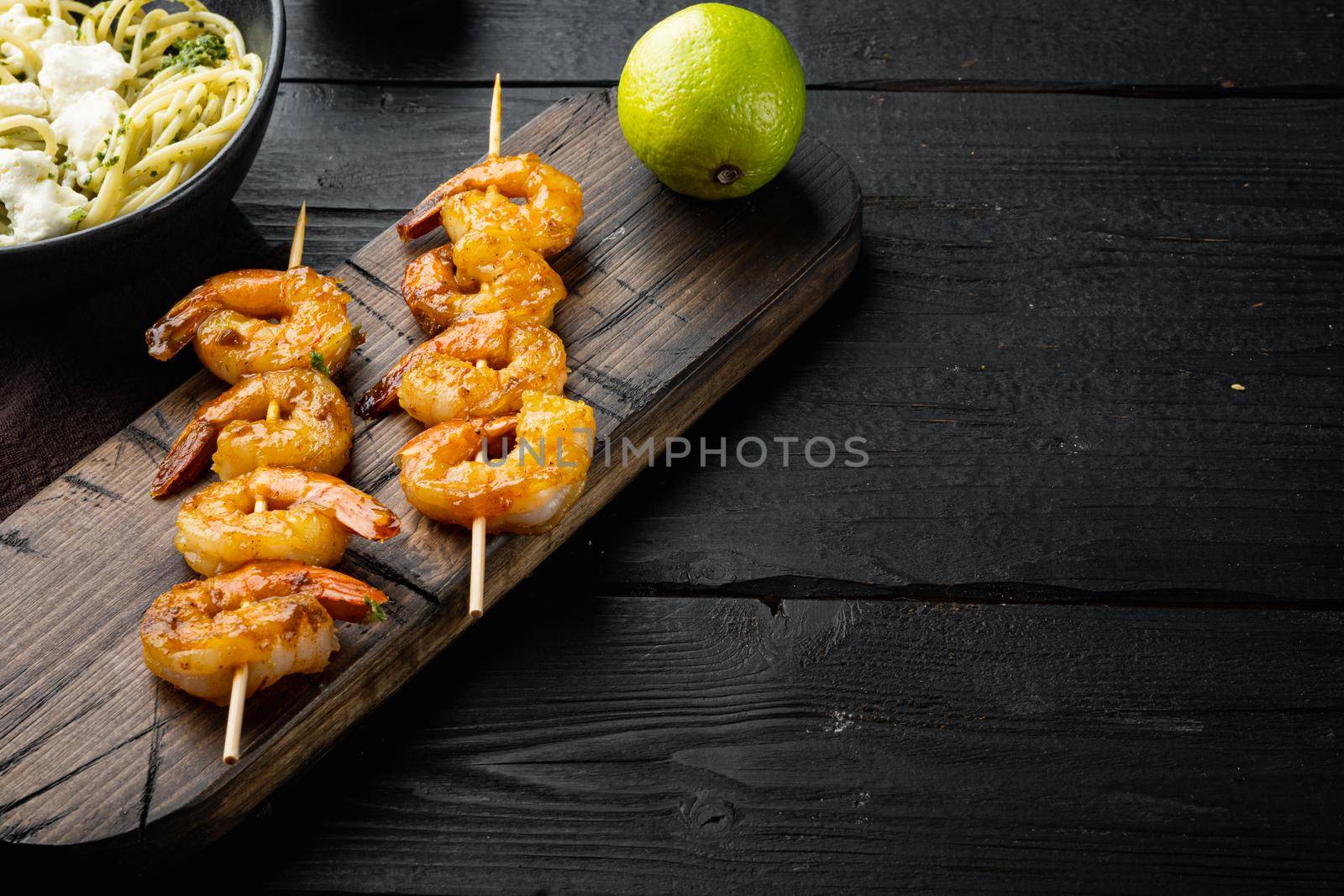 Traditional Italian dish. pasta with pesto ricotta parmesan and grilled seafood set, on black wooden table background , with copyspace and space for text