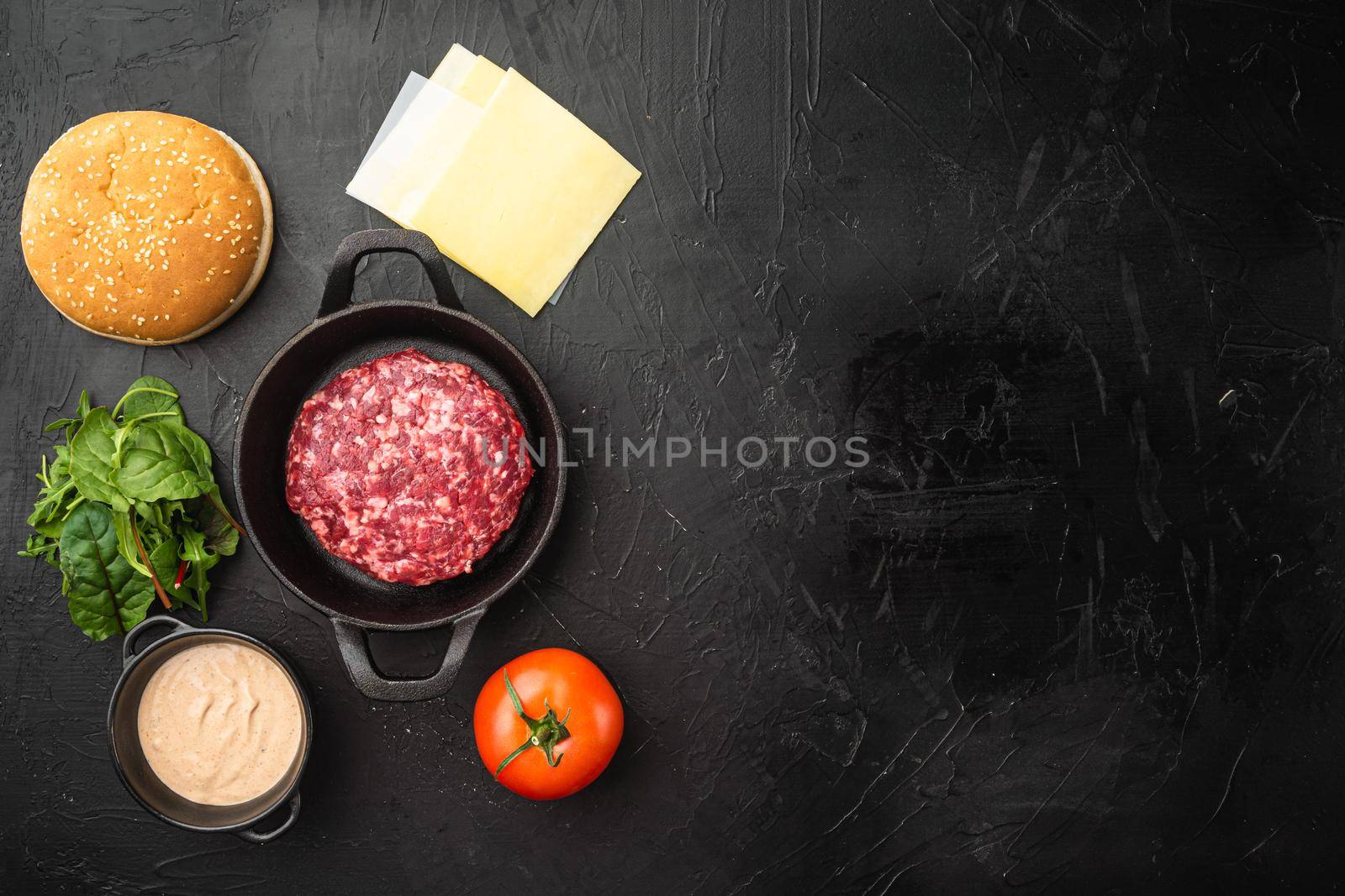 Raw Ground beef meat Burger steak cutlets with ingredients and buns set, on black stone background, top view flat lay, with copy space for text