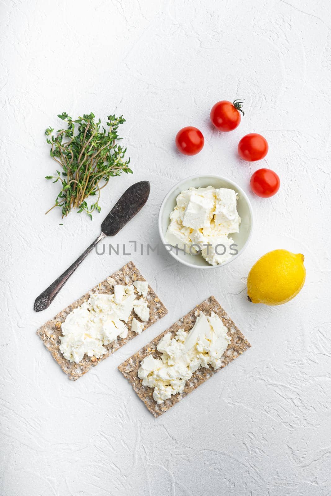 Wholegrain Rye Crispbread with cream cheese set, on white stone table background, top view flat lay, with copy space for text