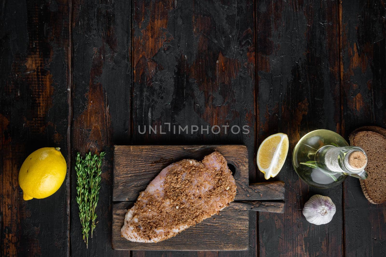Raw crumbet chicken fillet with ingredient, on wooden table, flat lay with copy space