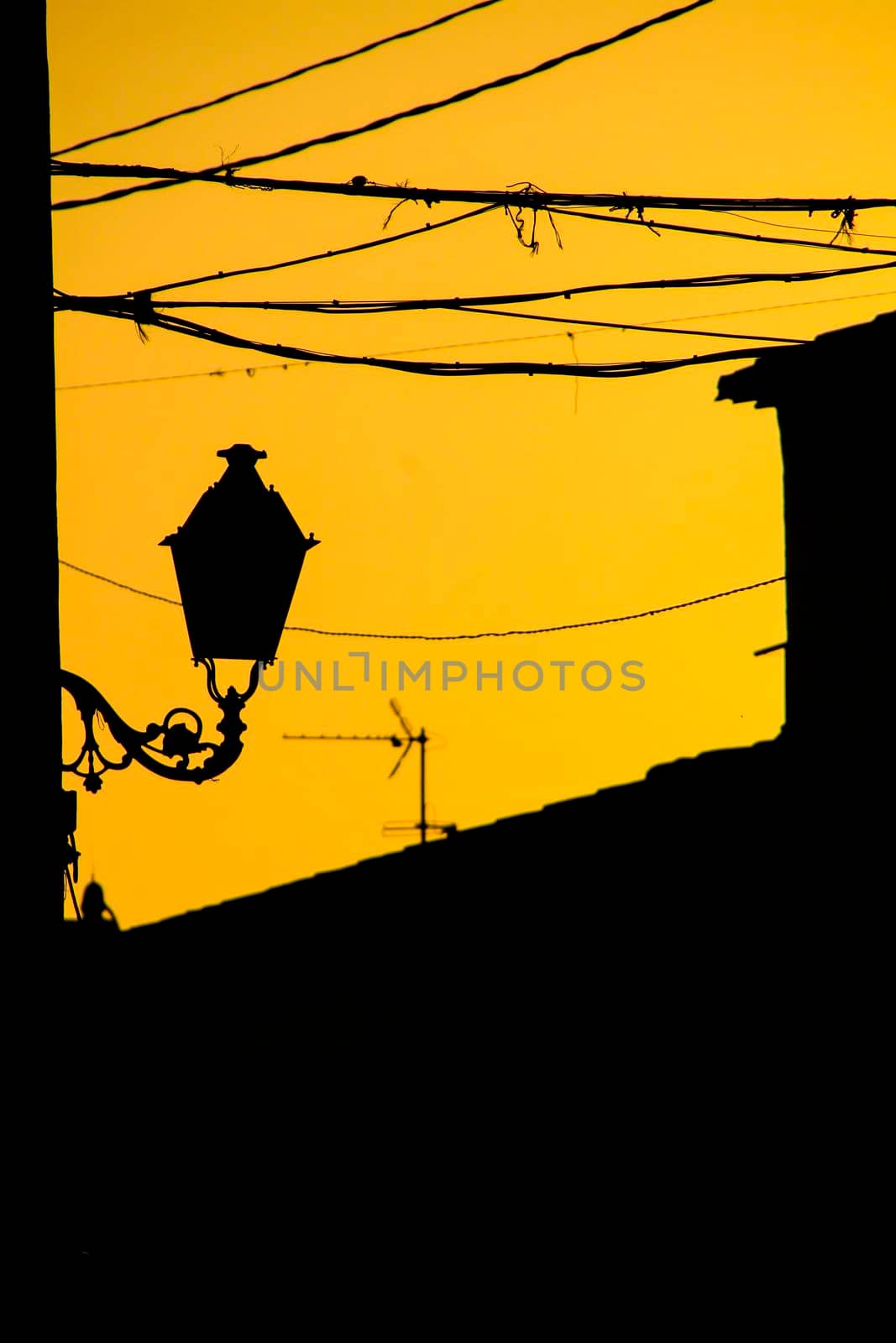 Orange sunset with houses and streetlight silhouettes in Altea, Alicante, Spain in summer