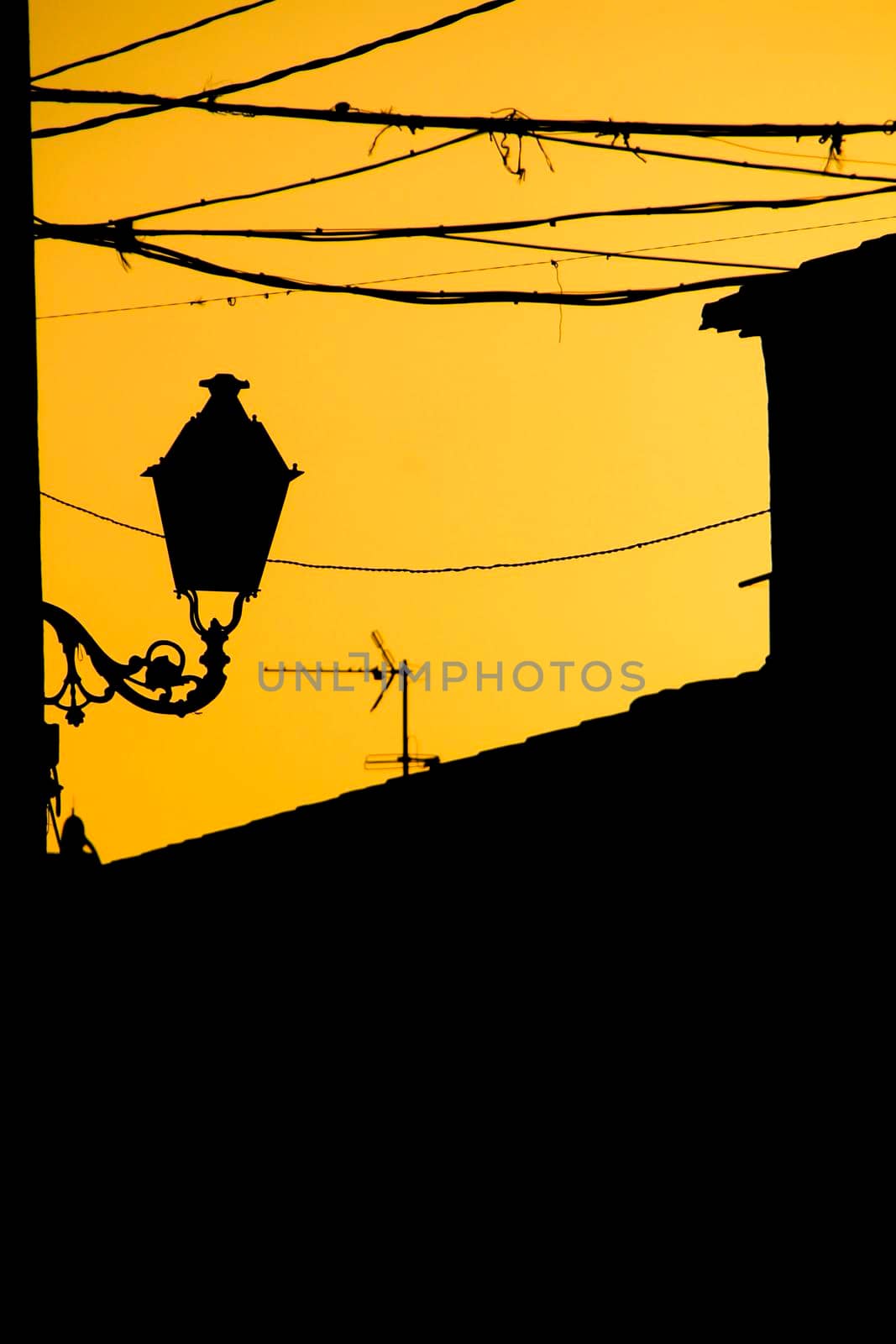 Orange sunset with houses and streetlight silhouettes in Altea, Alicante, Spain in summer