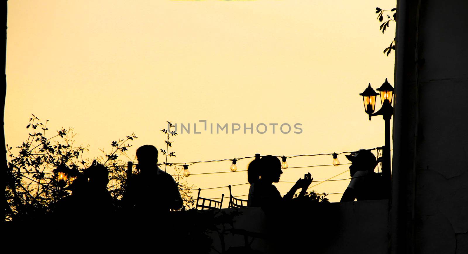 People enjoying and relaxing in a rooftop in Altea village at sunset in summer