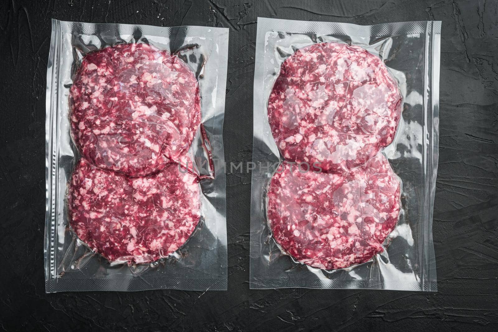 Vacuum beef cutlet sealed airtight pack set, on black stone background, top view flat lay