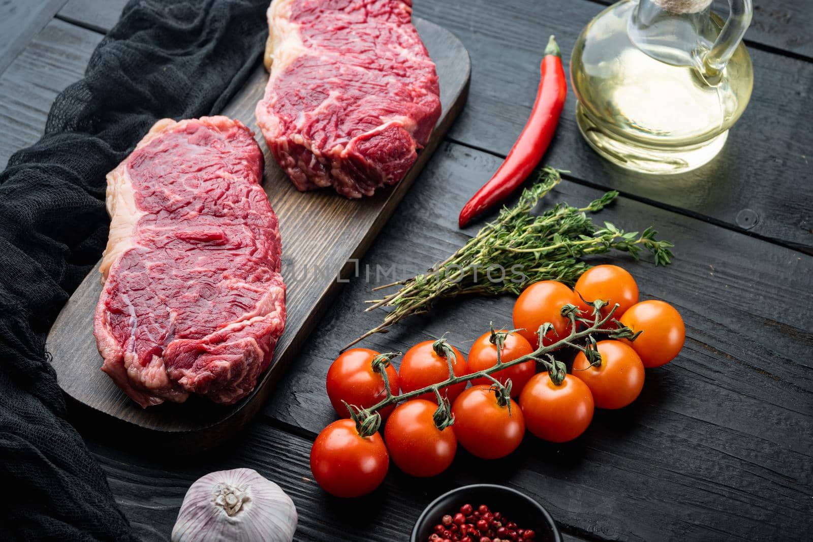 Veiny steak, marbled beef raw meat, on black wooden background