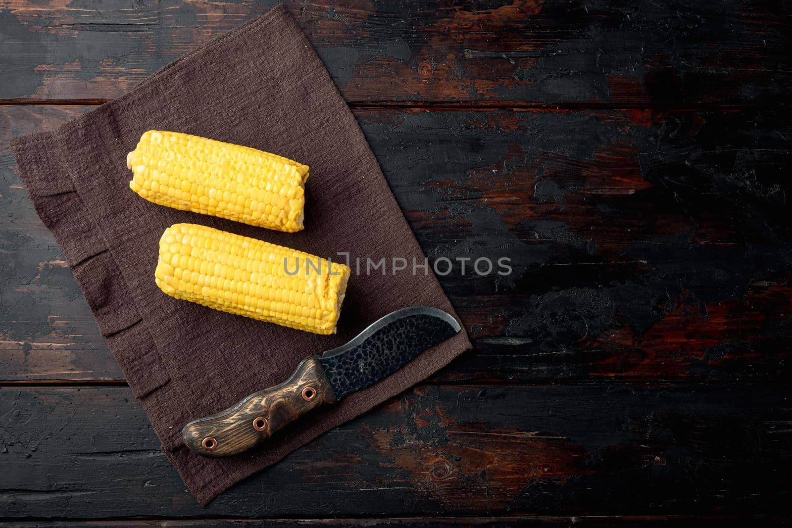 Homemade golden sweet corn cob set, on old dark wooden table background, top view flat lay, with copy space for text
