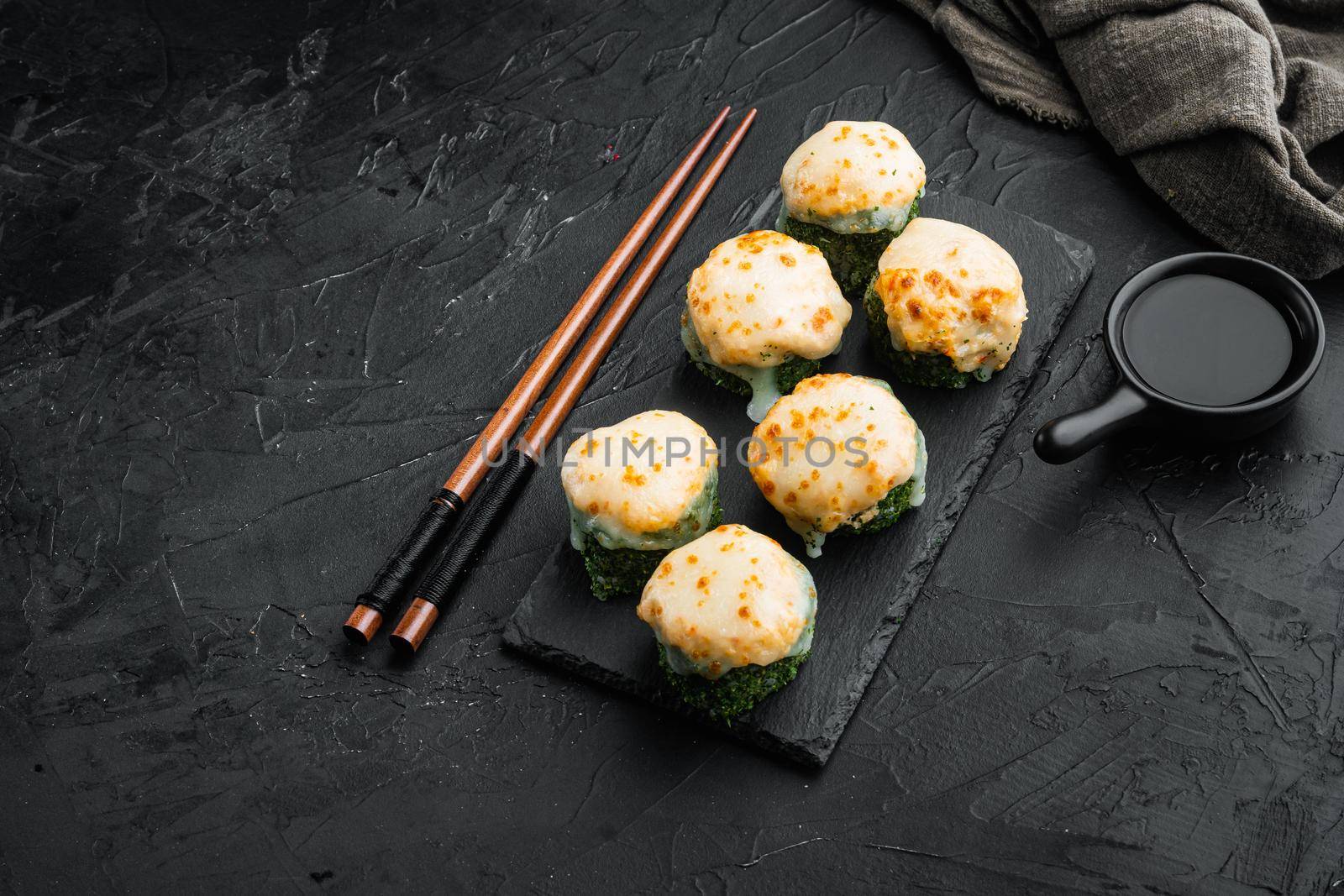 Japanese sushi rolls named Baked Ebi with wasabi and salmon fish set, on black stone background , with copyspace and space for text