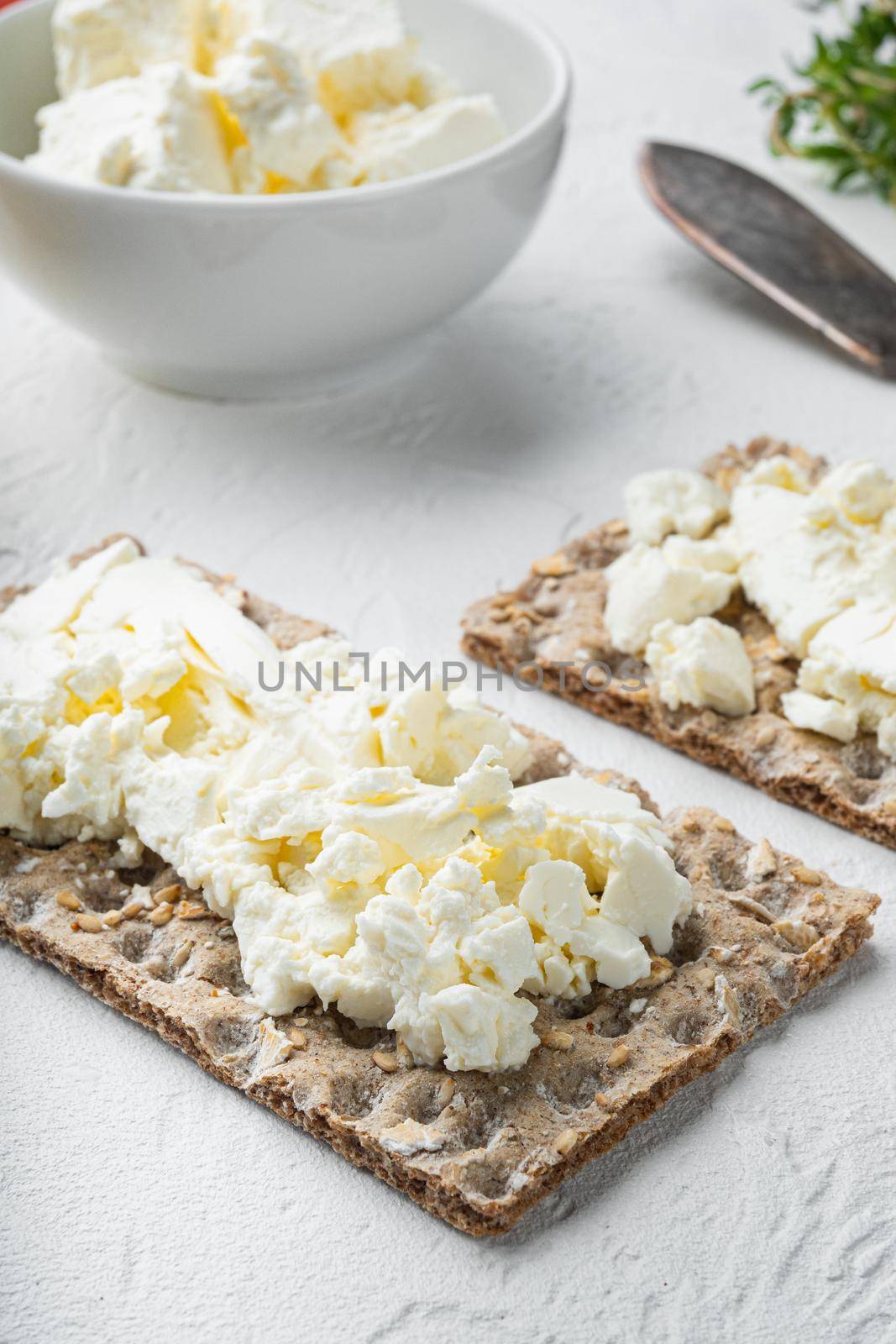 Crisp breads with butter set, on white stone table background