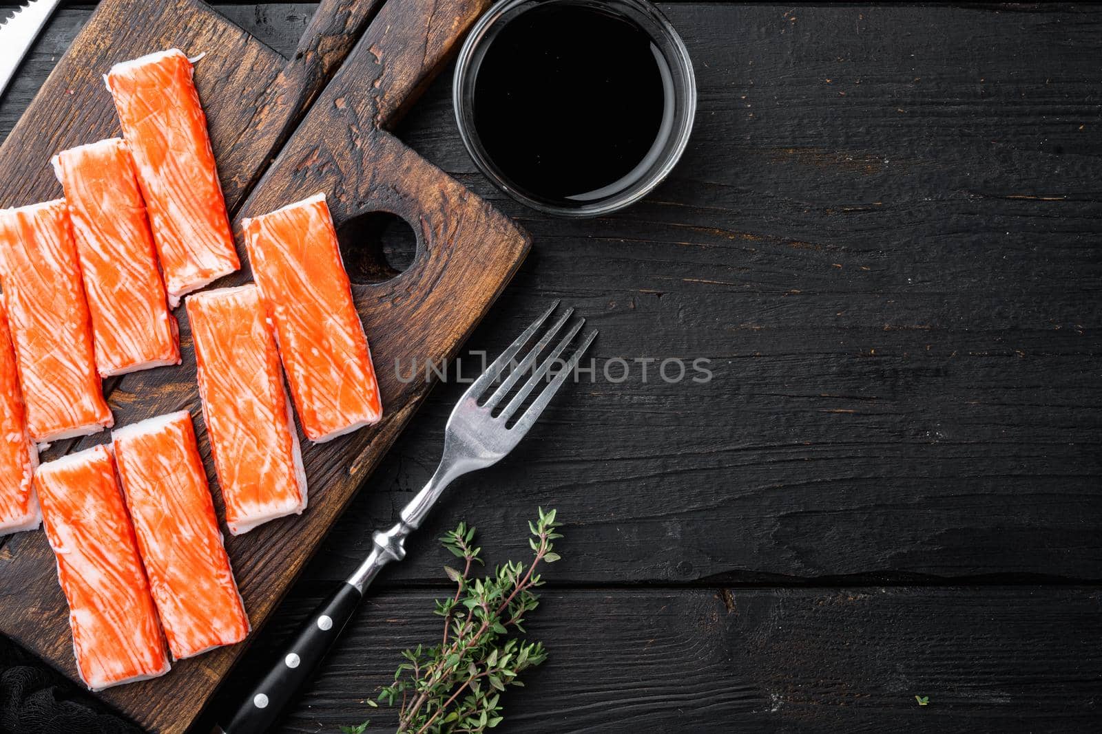 Asian snack surimi set, on wooden cutting board, on black wooden table background, top view flat lay , with copyspace and space for text