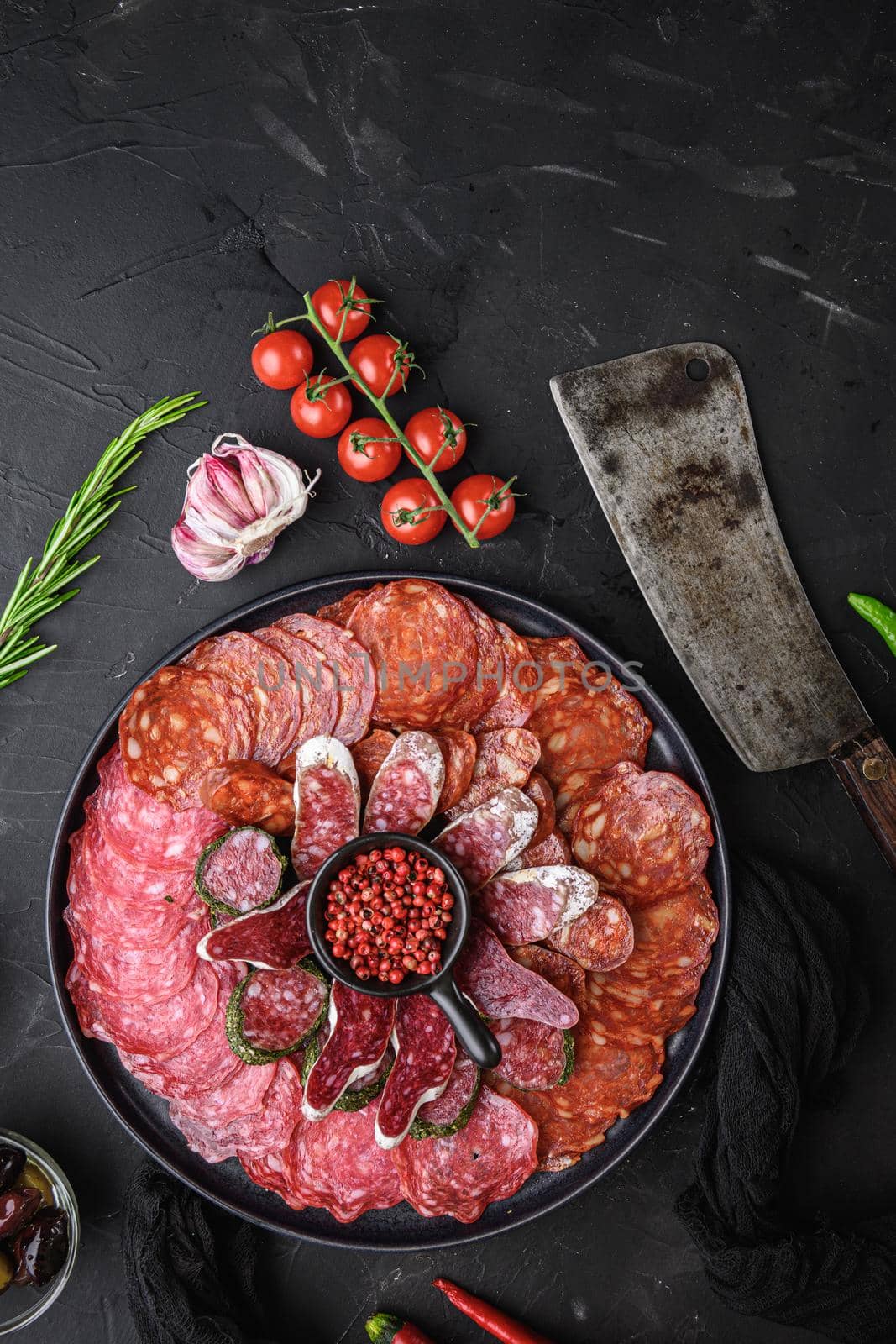 Spanish cold meat plate, chorizo, fuet, lomo,longaniza and salchichon on balck background, top view.