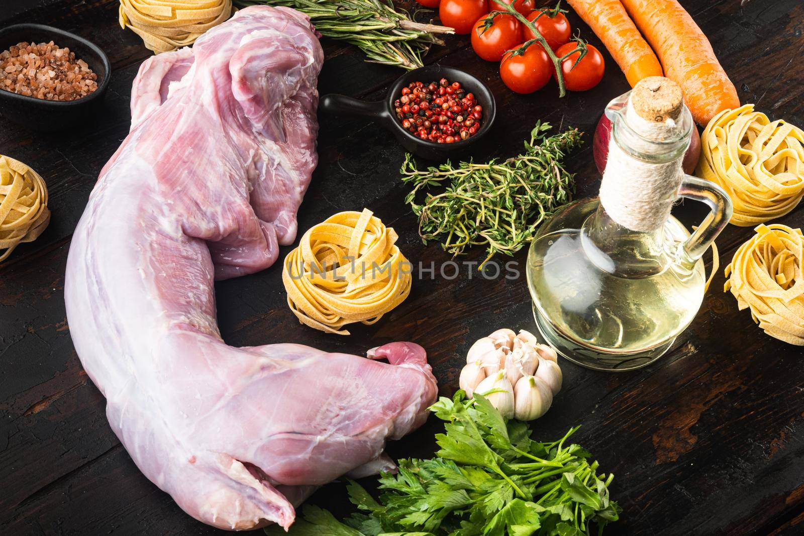 Raw fresh whole rabbit cut for stewing set, on old dark wooden table background