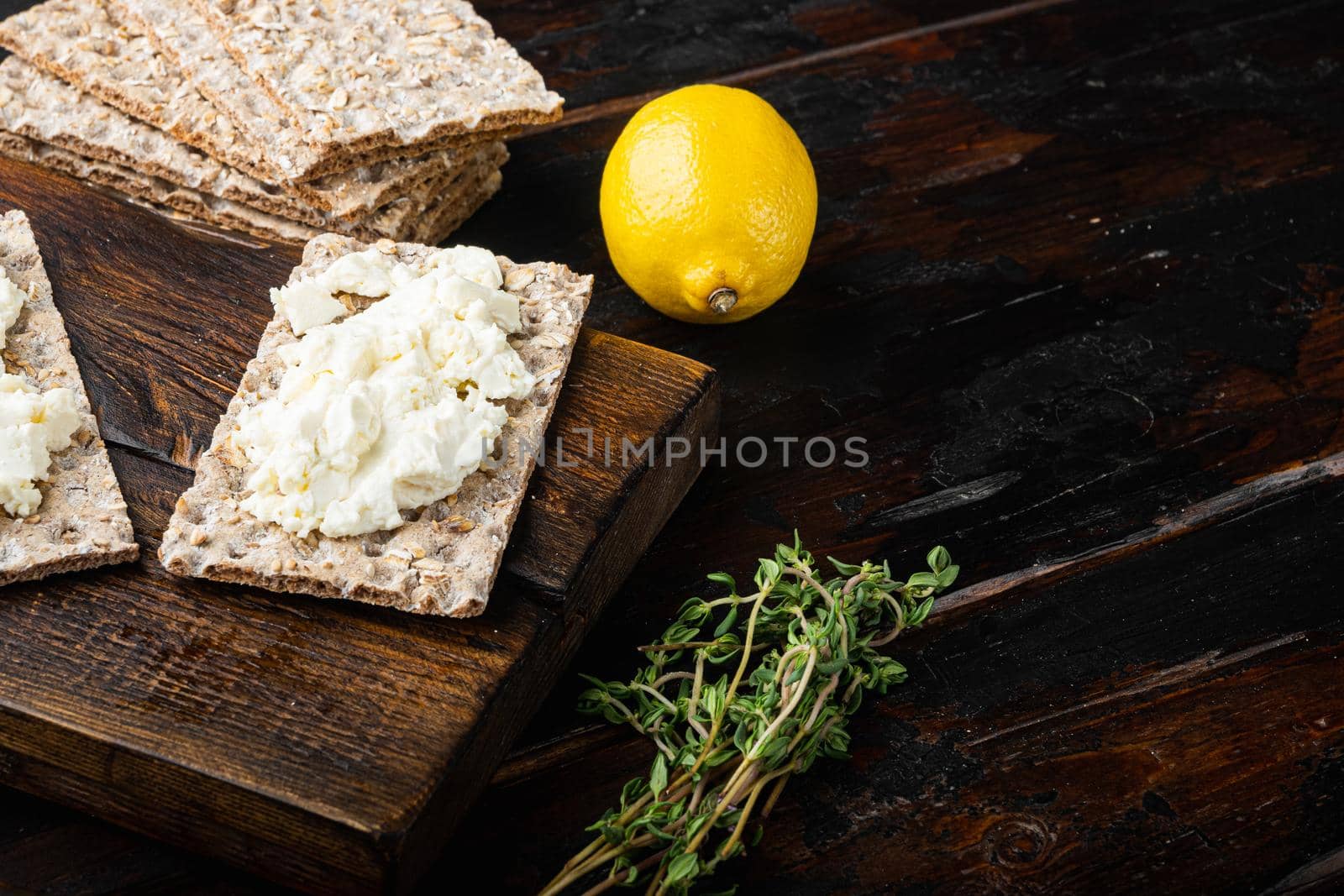 Curd sandwiches with fresh herbs. Crispbread toast with cottage cheese set, on old dark wooden table background, with copy space for text