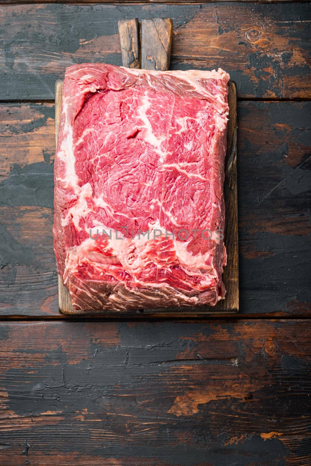 Veiny steak, marbled beef raw meat, on dark wooden background, top view