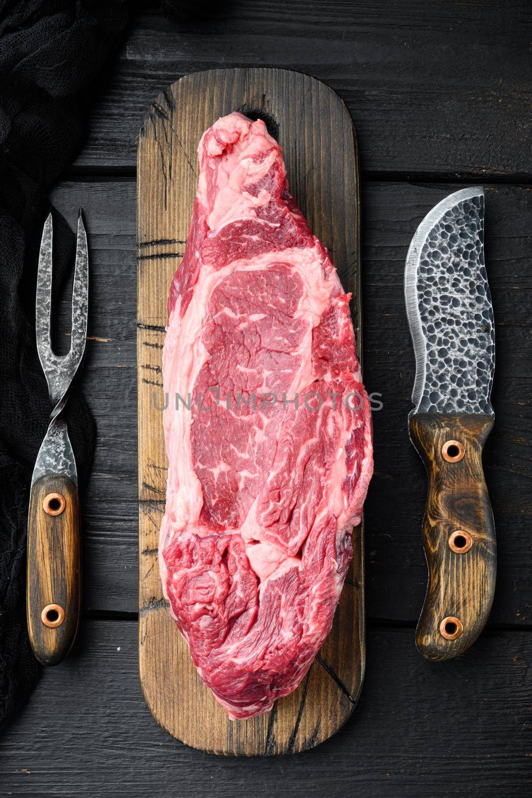 Rib eye beef meat cut raw set, on black wooden table background, top view flat lay