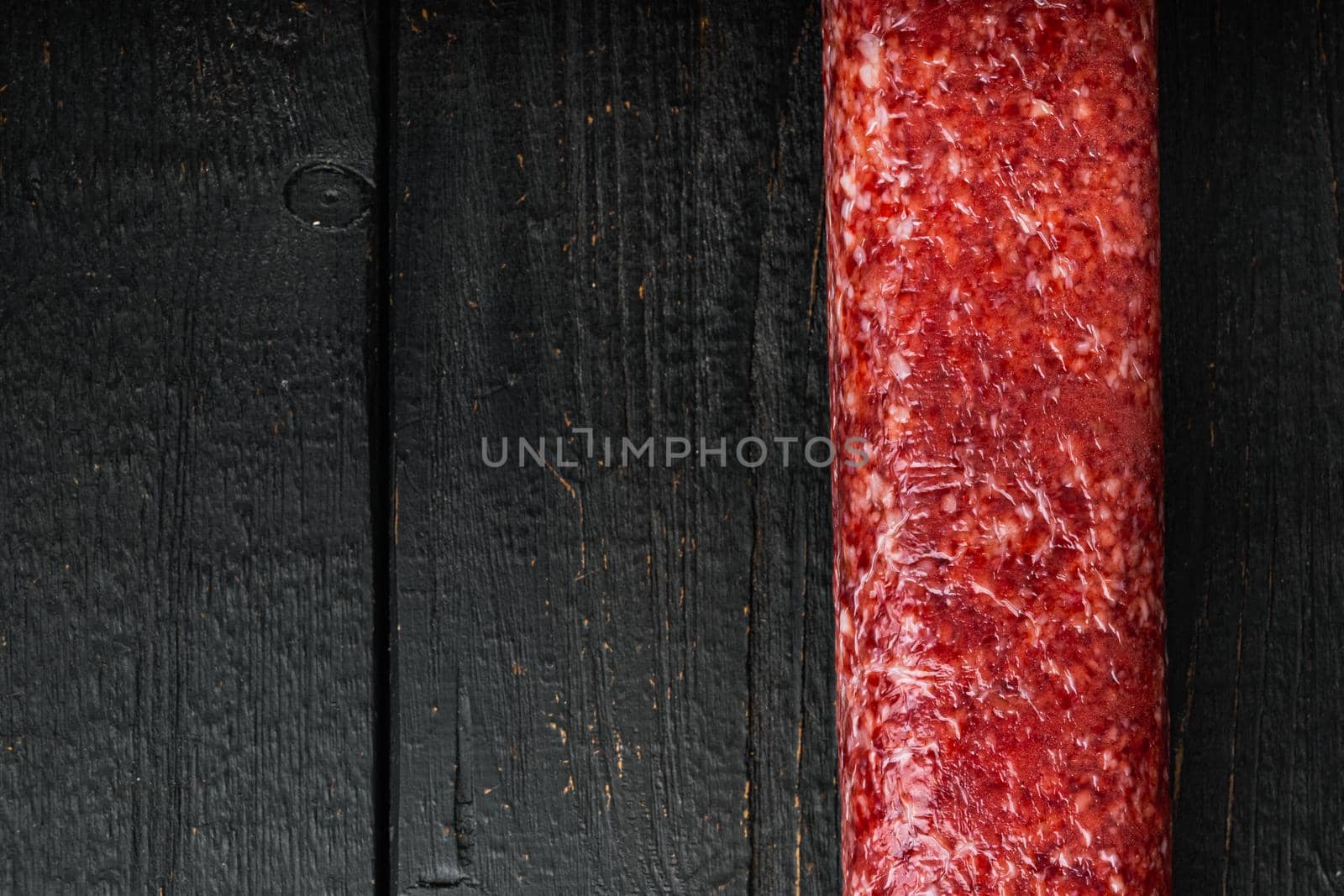 Fresh salami set, on black wooden table background, top view flat lay, with copy space for text