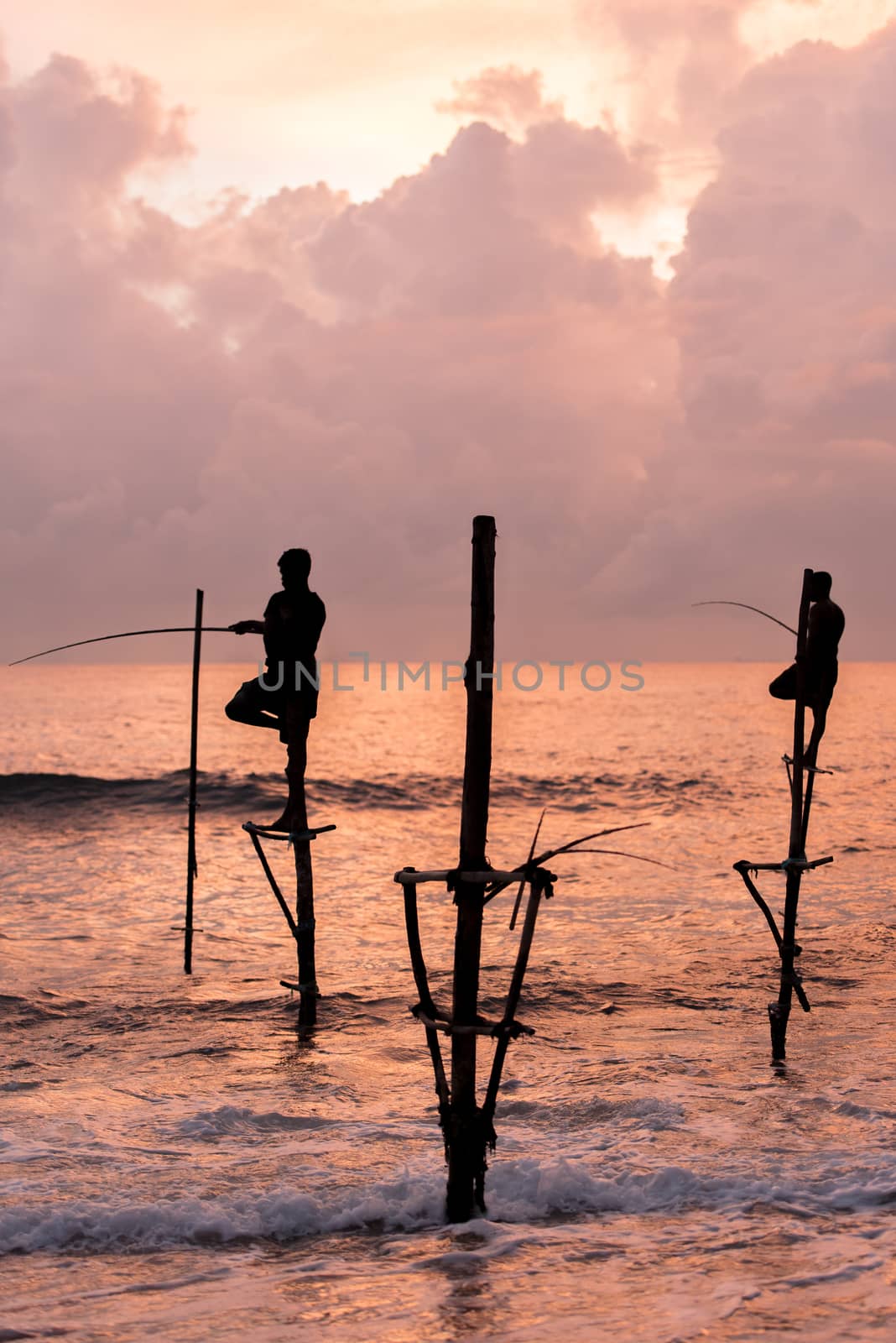 Silhouettes of the traditional Sri Lankan stilt fishermen on a stormy in Koggala, Sri Lanka. Stilt fishing is a method of fishing unique to the island country of Sri Lanka by martinscphoto