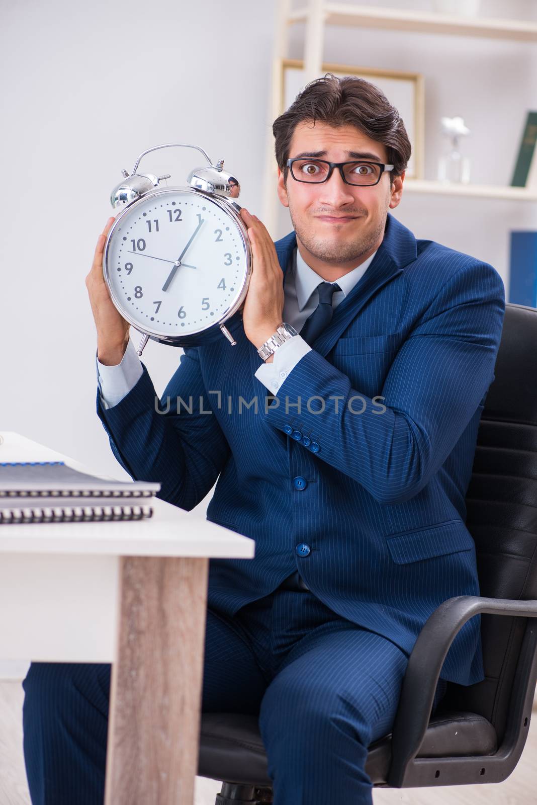 Businessman employee in urgency and deadline concept with alarm clock