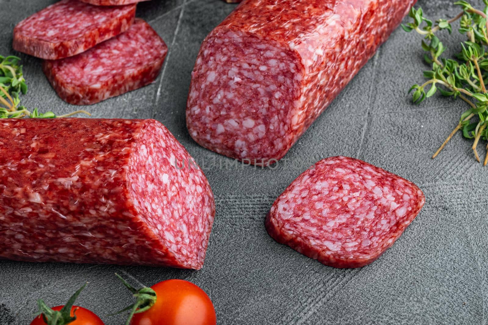 Salami with herbs , garlic set, on gray stone table background