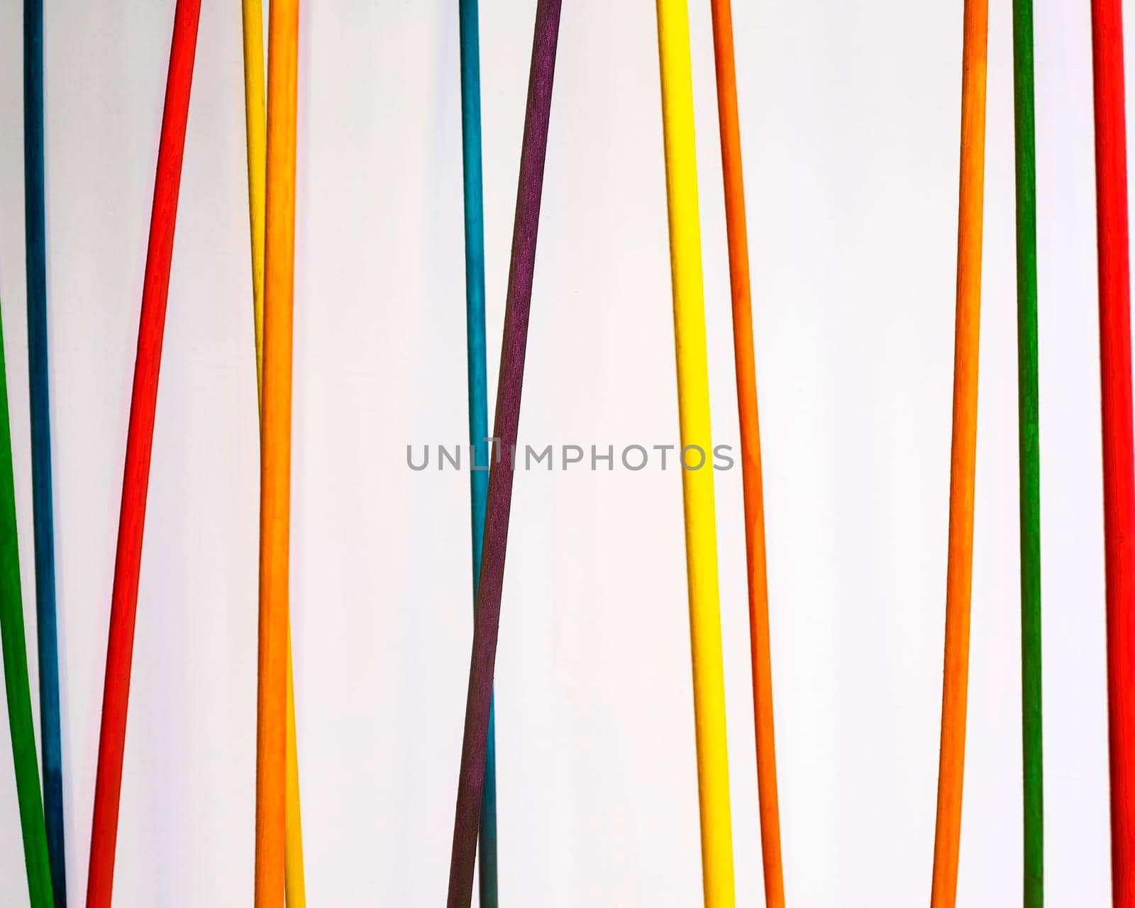 Colored dowels hang against a white background.