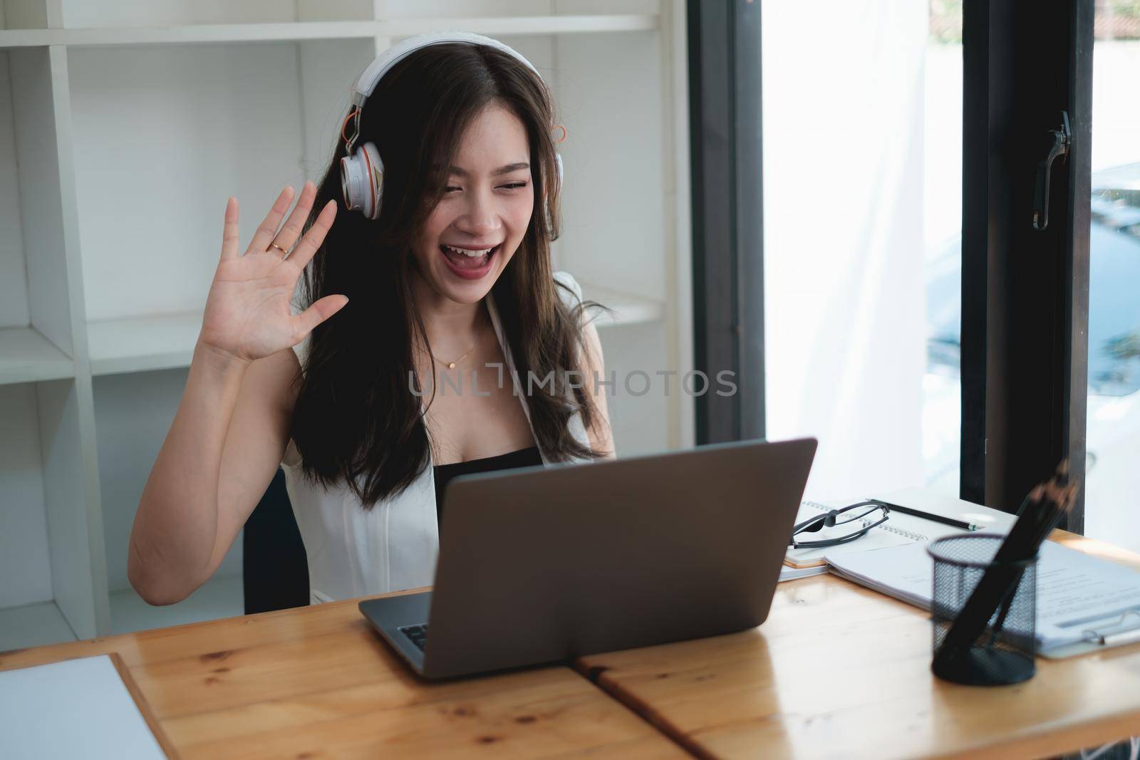 Young woman gammer or blogger influencer sit looking at camera make video conference call recording vlog in living room at her home