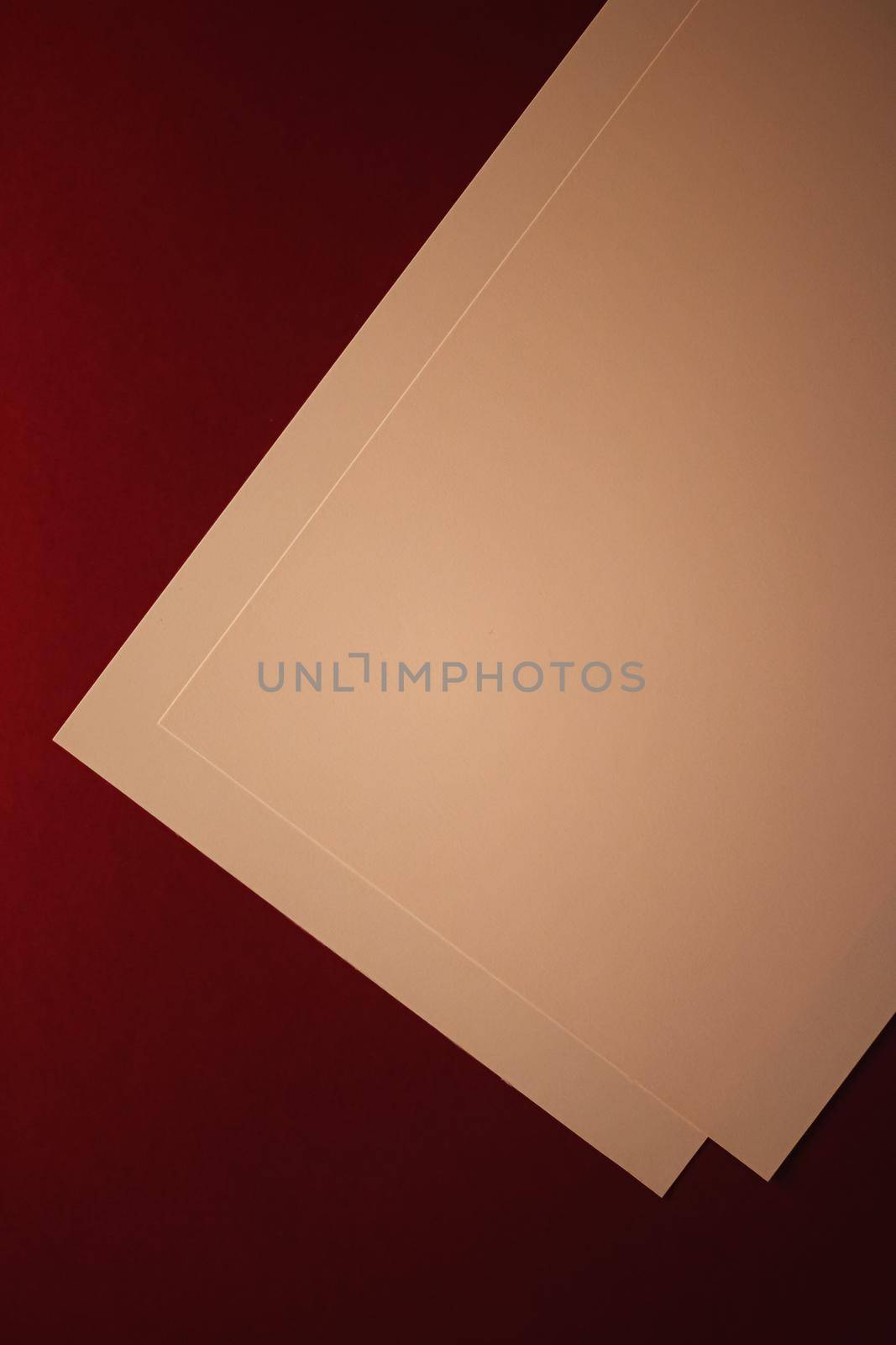 Blank A4 paper, beige on dark red background as office stationery flatlay, luxury branding flat lay and brand identity design for mockups