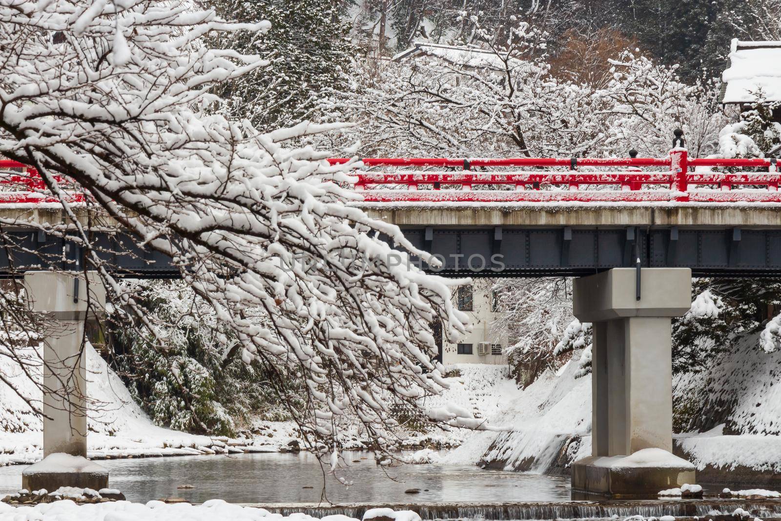 Nakabashi Bridge with snow fall and Miyakawa river in winter season . Landmark of Hida , Gifu , Takayama , Japan . Landscape view .