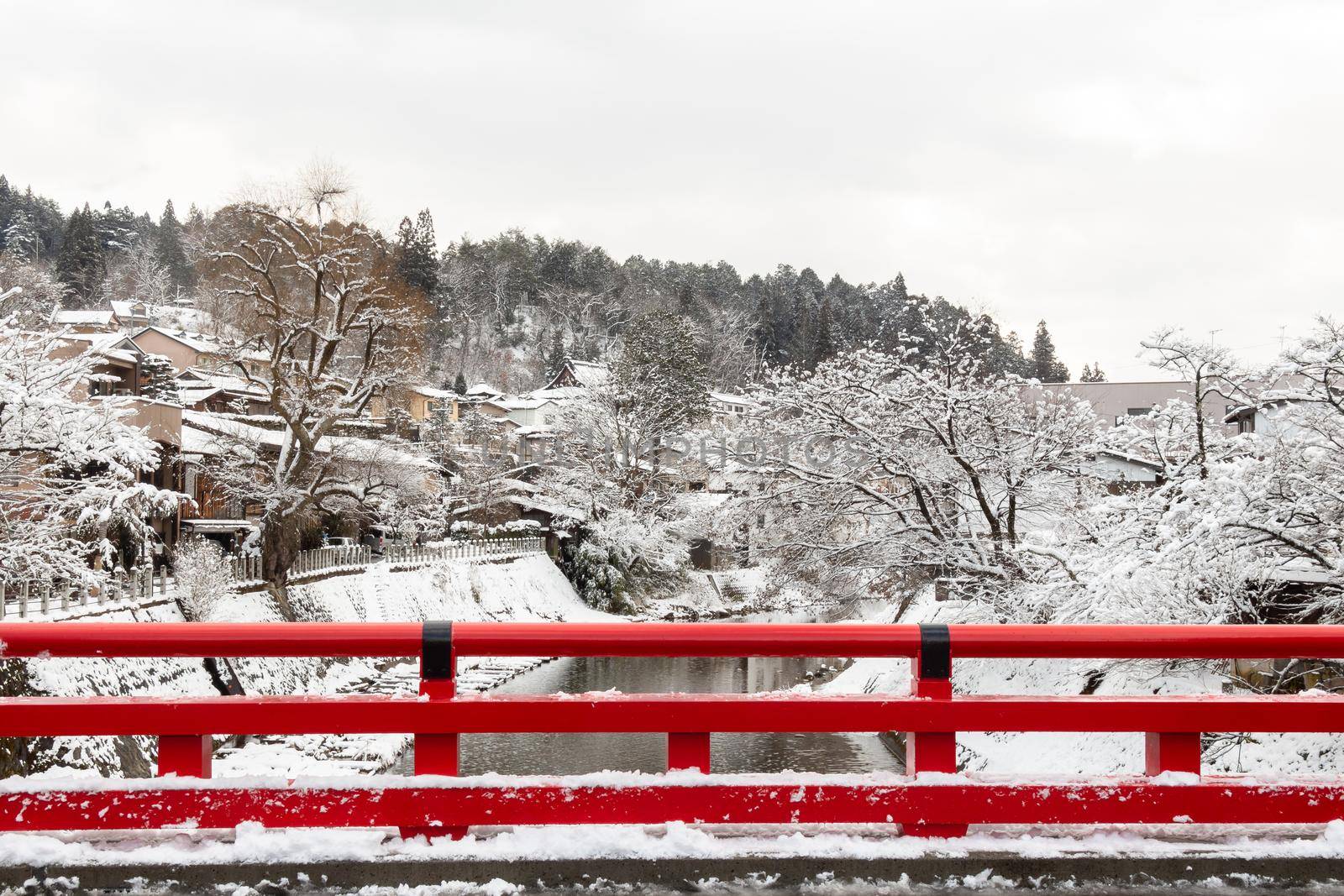 Nakabashi Bridge with snow fall and Miyakawa river in winter season . Landmark of Hida , Gifu , Takayama , Japan . Landscape view .