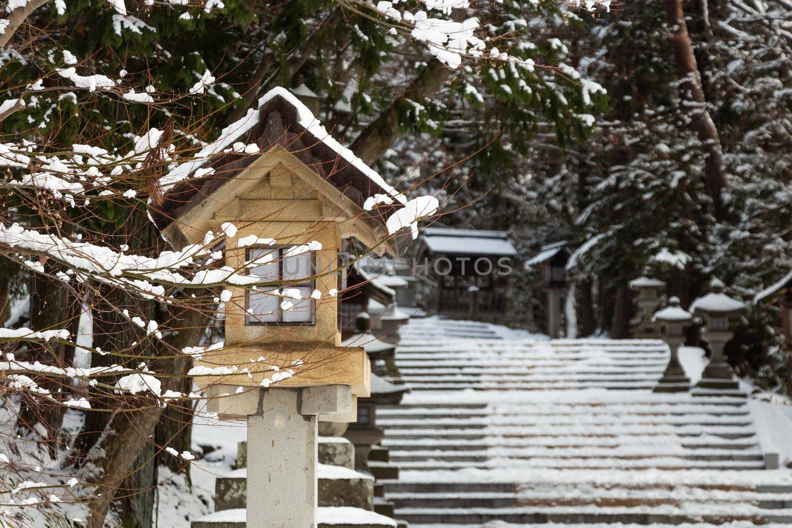 Japanese stone and wooden lantern with snow at Hida-sannogu Hie-Jinja shrine in winter season . At Gifu , Hida Takayama , Japan . by stockdevil