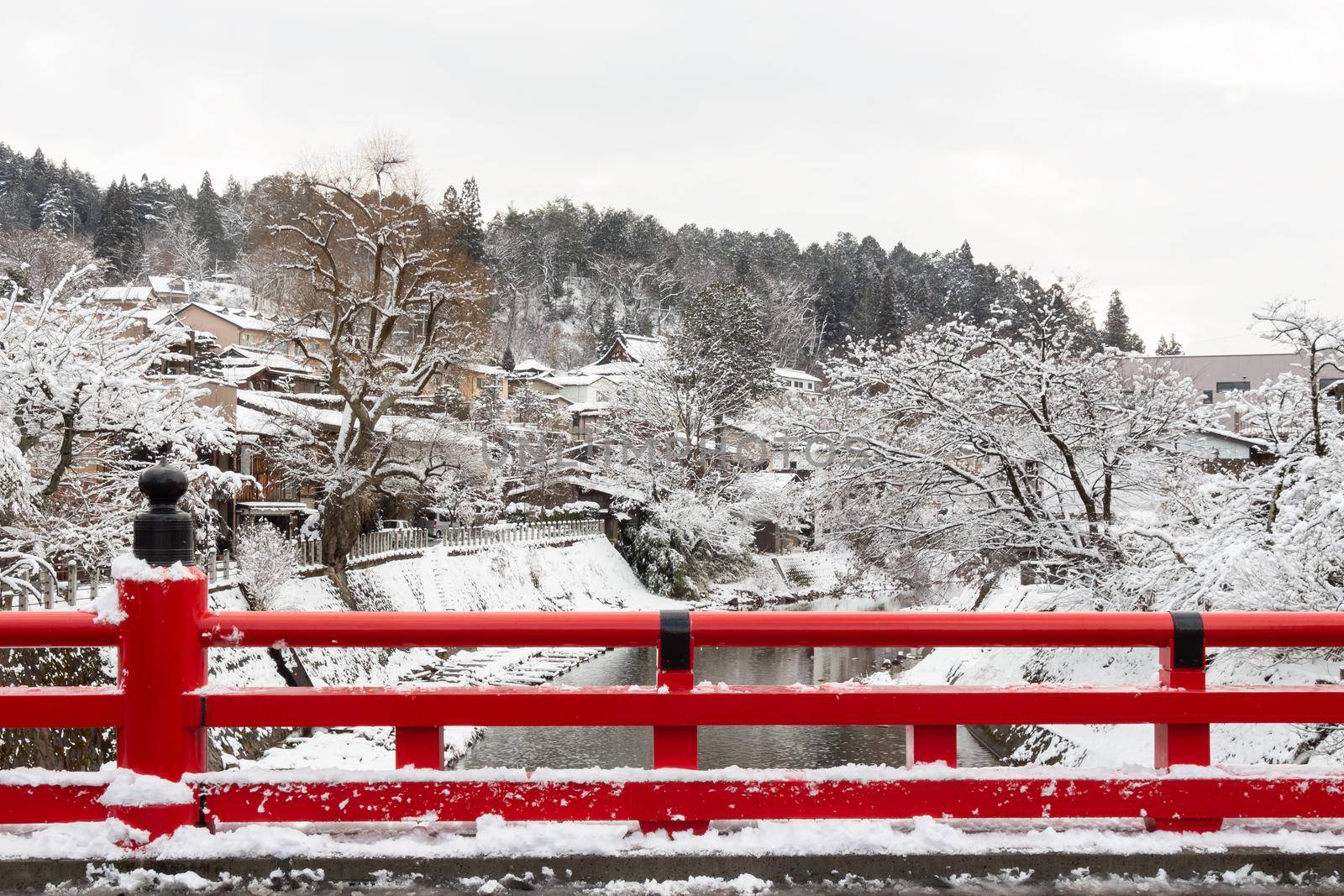 Nakabashi Bridge with snow fall and Miyakawa river in winter season . Landmark of Hida , Gifu , Takayama , Japan . Landscape view .