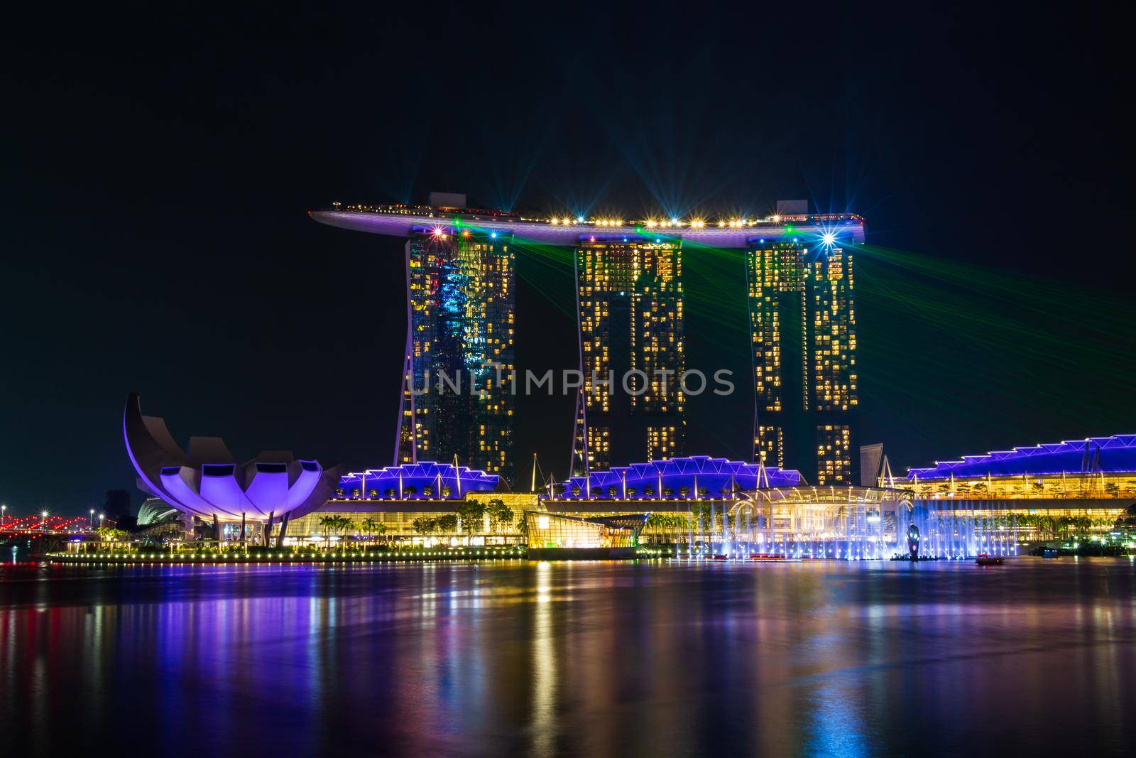 Singapore skyline cityscape with light and water show around marina bay at night .