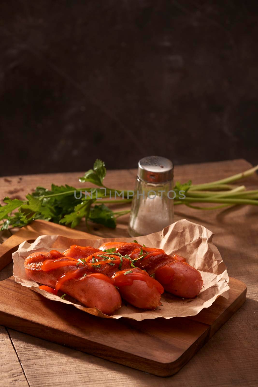 Grilled sausages with sauce ketchup on a wooden table