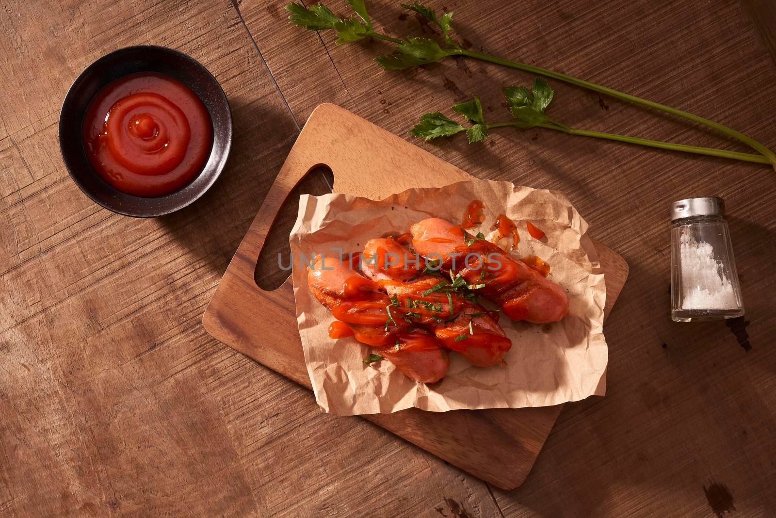 Grilled sausages with sauce ketchup on a wooden table