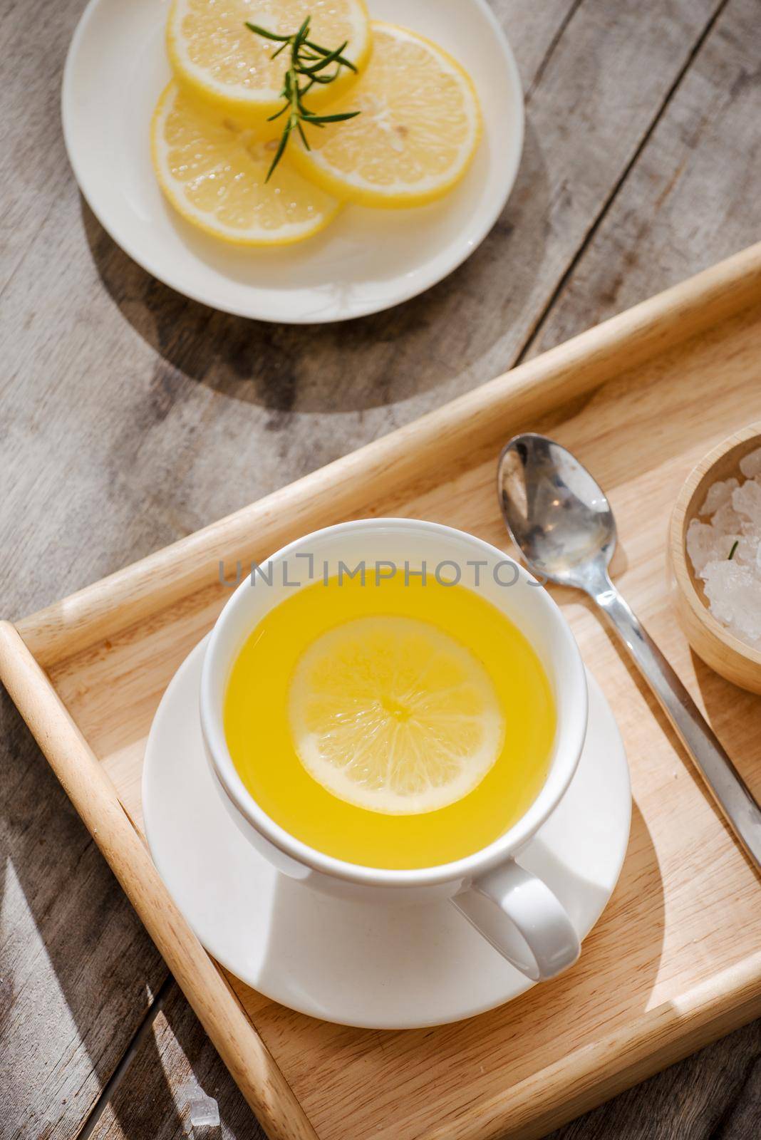 Cup of Ginger tea with lemon. Cup of Ginger tea with lemon. Glass mug of green hot tea on wooden table. Sliced lemons on a chopping board