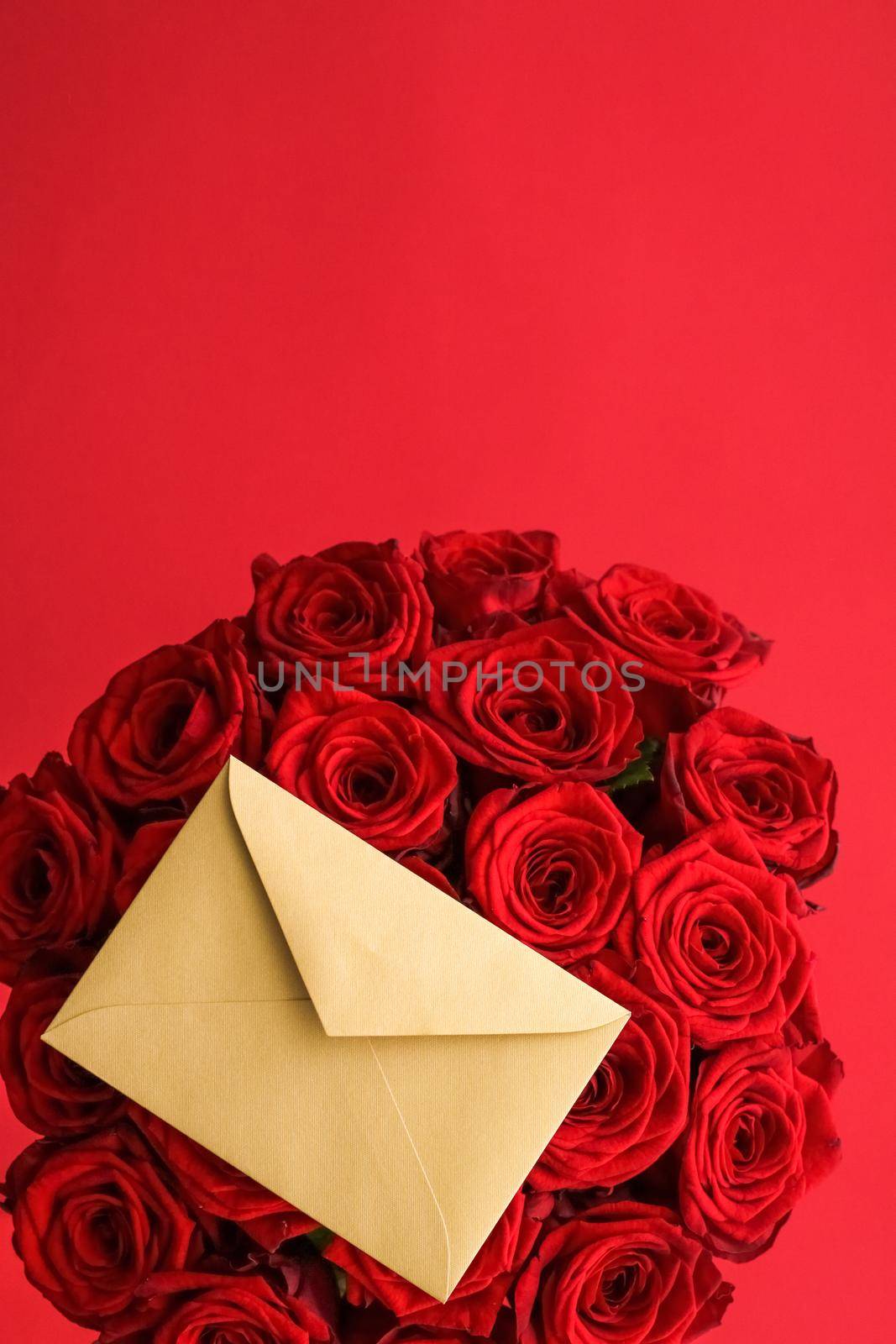 Holiday gift, flowers flatlay and happy relationship concept - Love letter and flower delivery service on Valentines Day, luxury bouquet of red roses and card envelopes on red background