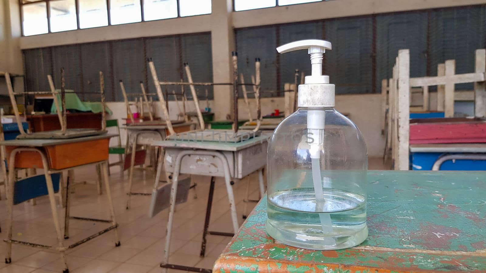 Alcohol gel is placed in a bottle in front of the classroom for students to wash their hands before entering the room.