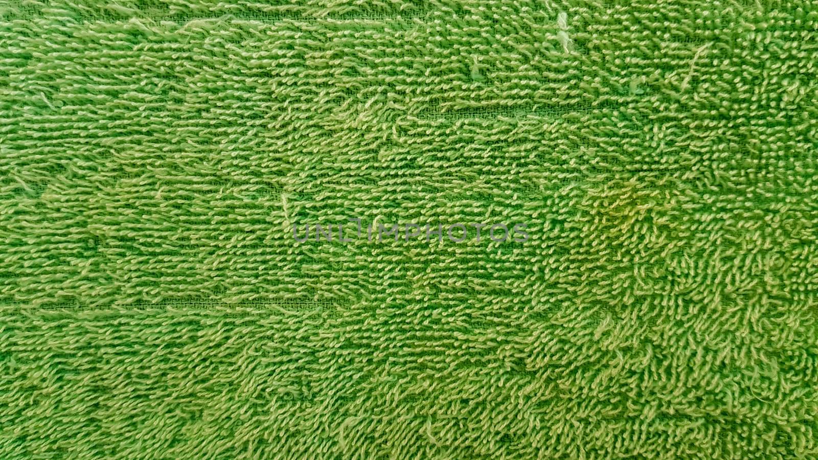 green old towel texture for background The fabric or textile is made up of cotton fiber material, looks fluffy, dry, soft.
