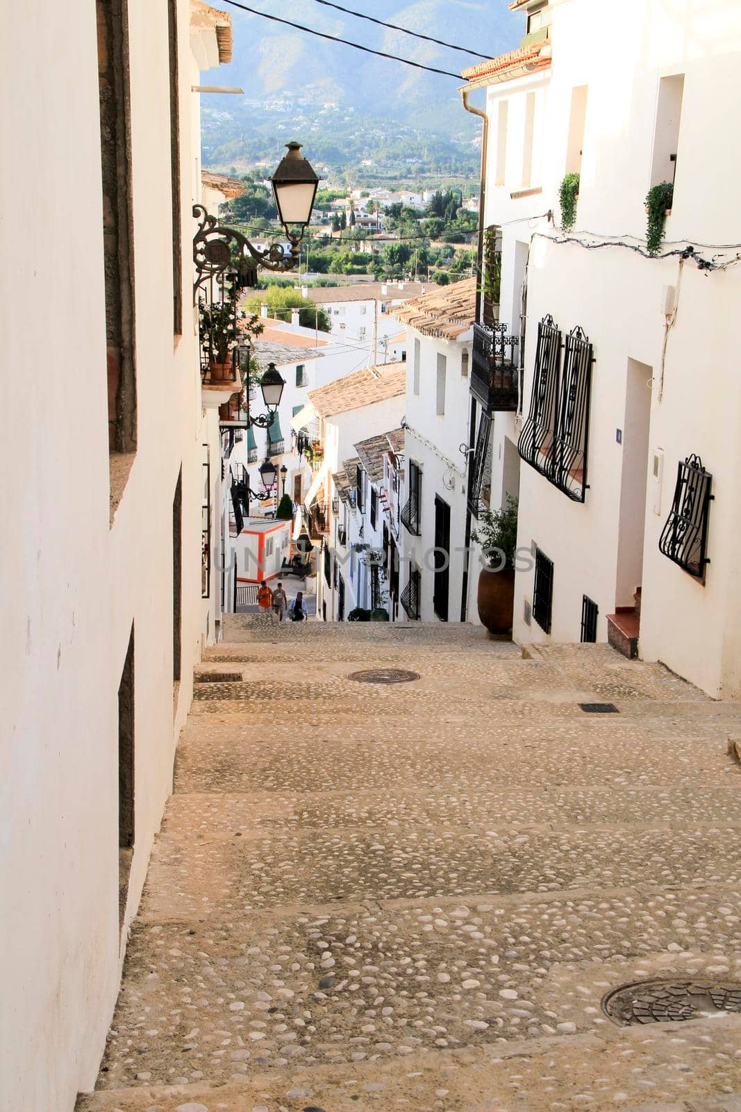 Altea, Alicante, Spain- June 12, 2021: Narrow streets and typical whitewashed facades in Altea village, Alicante, Spain