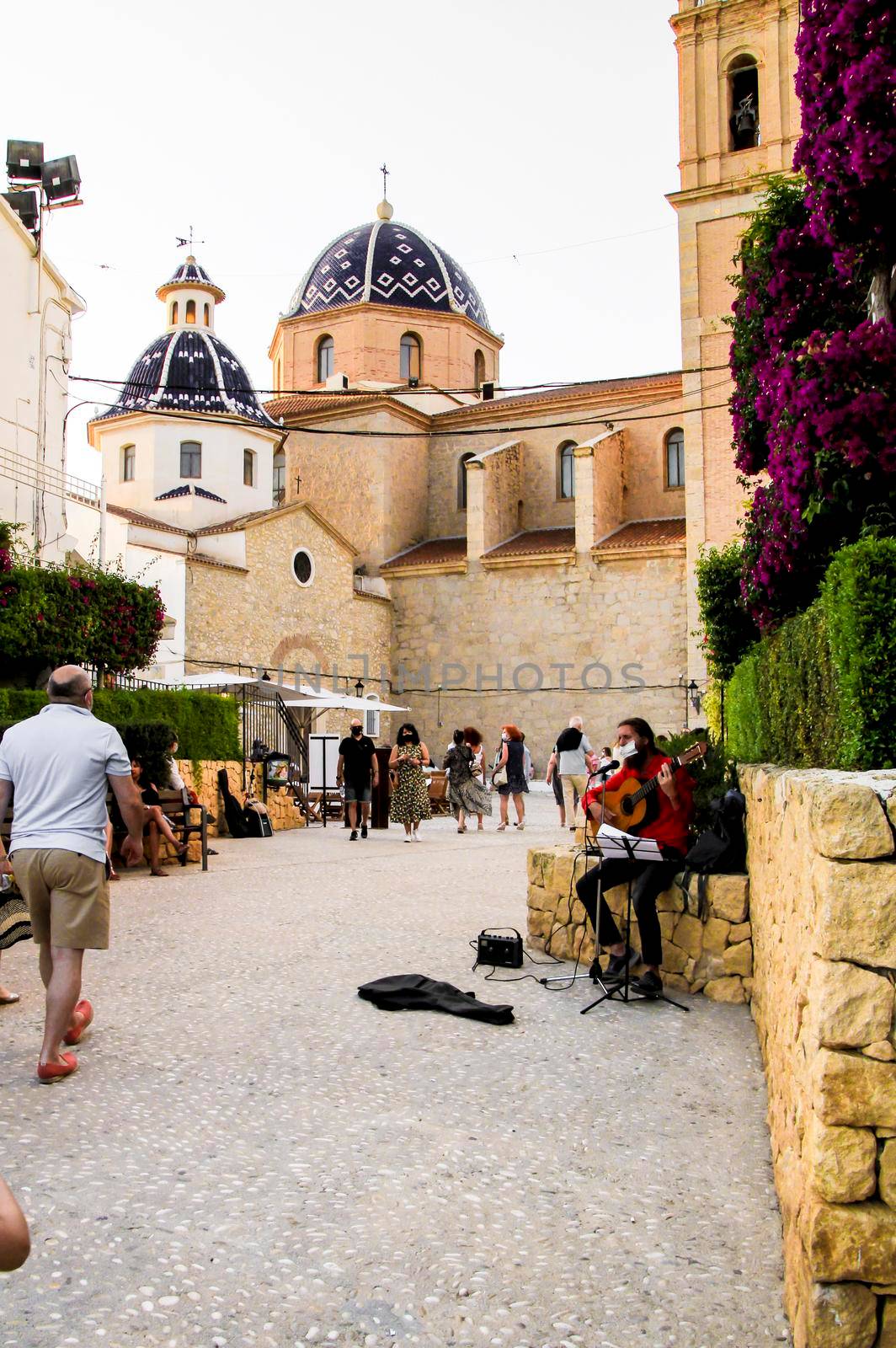 Altea, Alicante, Spain- June 12, 2021: Musician playing the guitar and begging in the main square of Altea village in Alicante, Spain