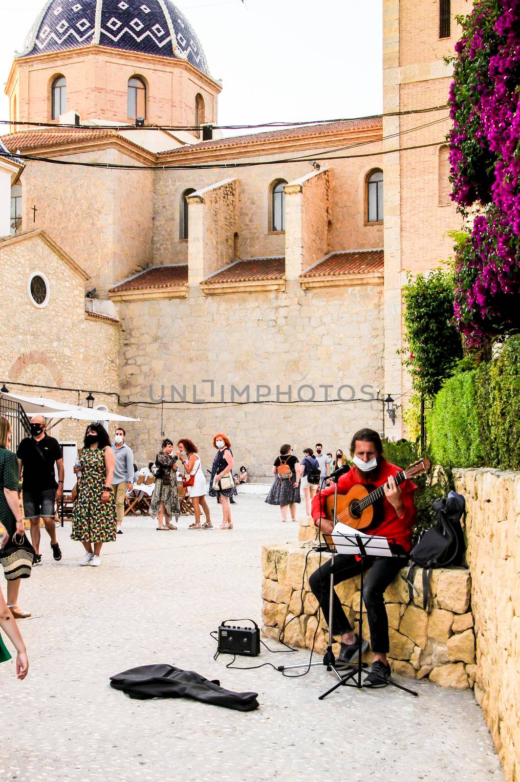 Altea, Alicante, Spain- June 12, 2021: Musician playing the guitar and begging in the main square of Altea village in Alicante, Spain