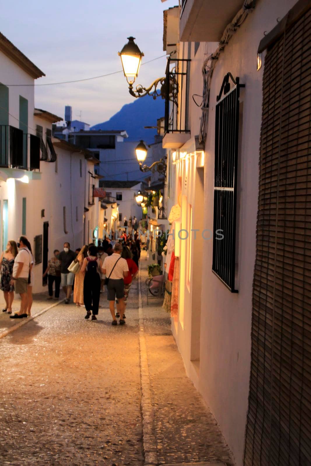 Altea, Alicante, Spain- June 12, 2021: People going shopping, walking and relaxing at night through the Narrow streets of Altea village, Alicante, Spain