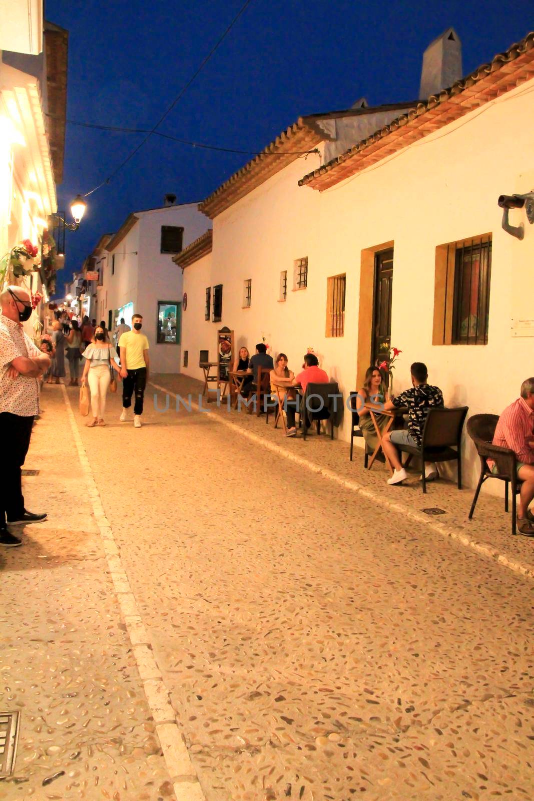 Altea, Alicante, Spain- June 12, 2021: People having drinks and enjoying nice weather in terraces at night in Altea village in Spain. 