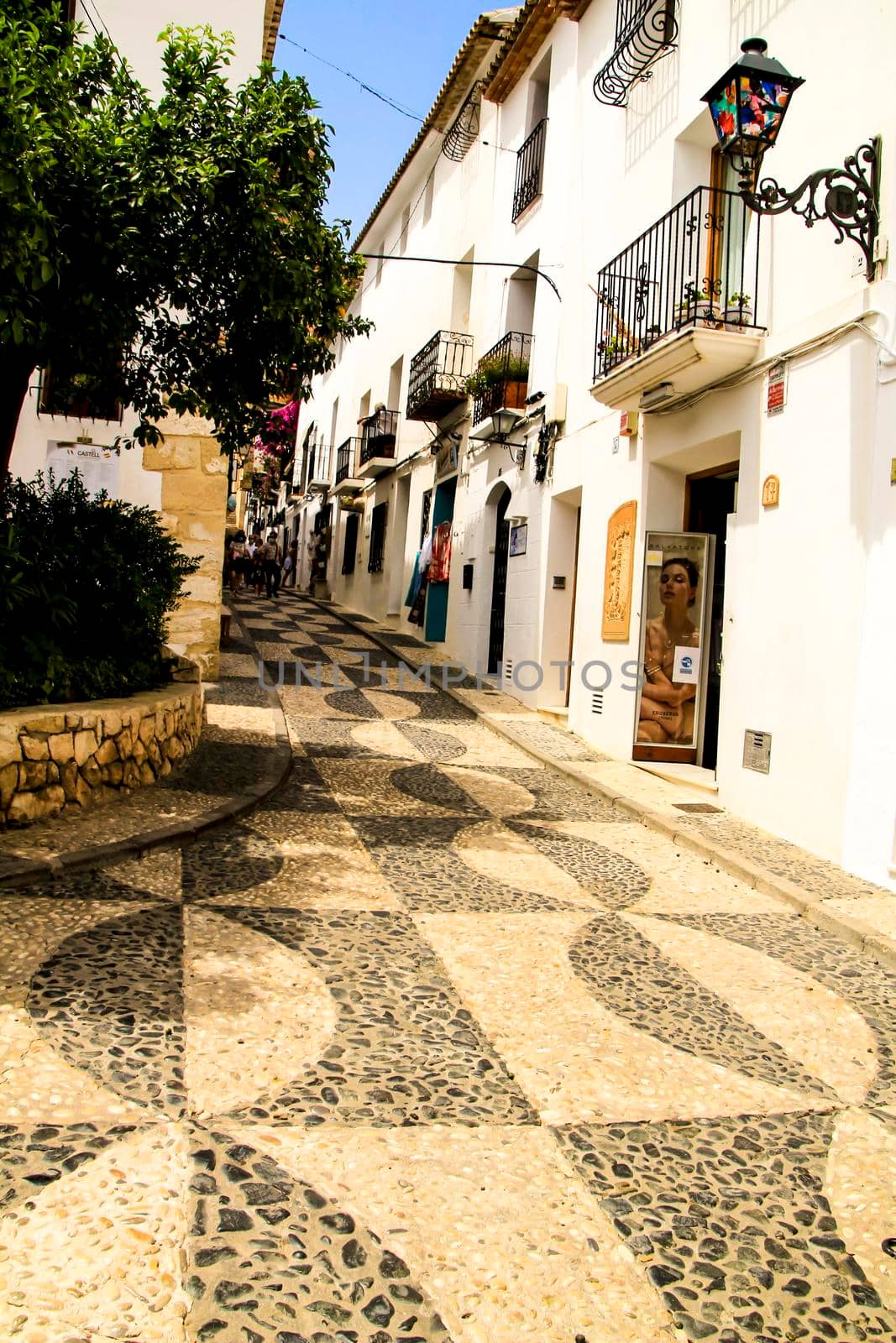 Altea, Alicante, Spain- June 12, 2021: Narrow streets and typical whitewashed facades in Altea village, Alicante, Spain