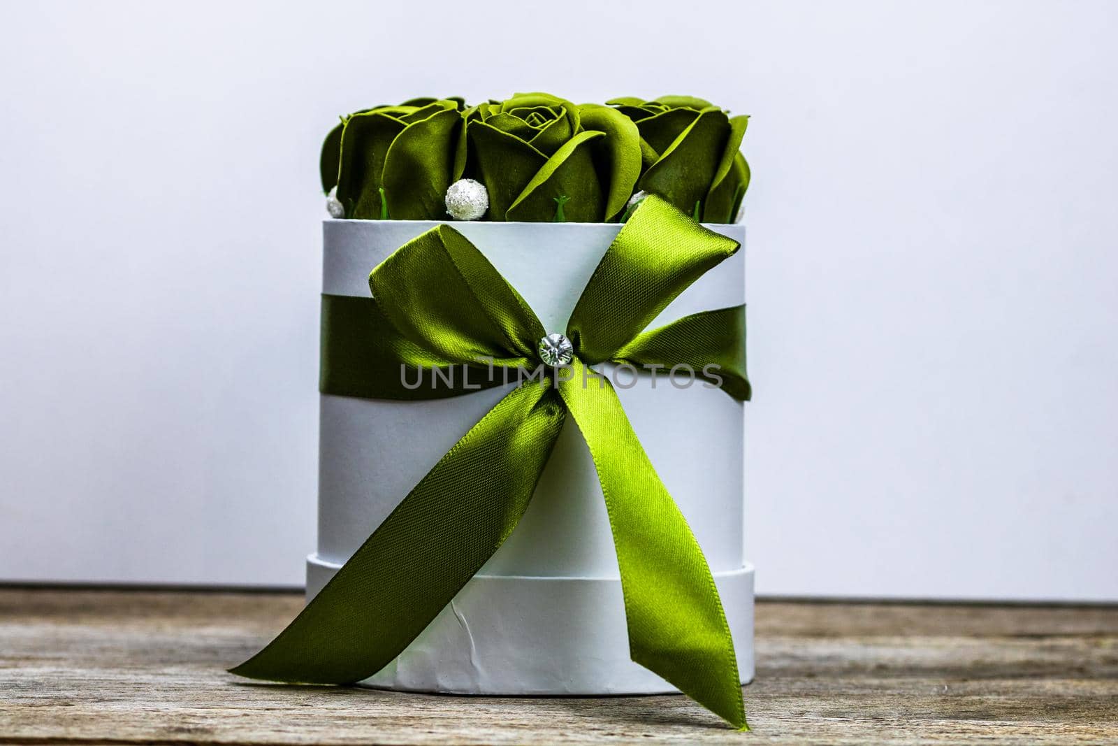 Green roses in a round luxury present box. Bouquet of flowers in a paper box isolated.