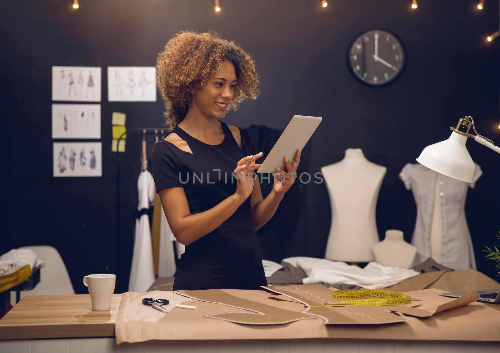 A young fashion designer on her atelier working with a tablet