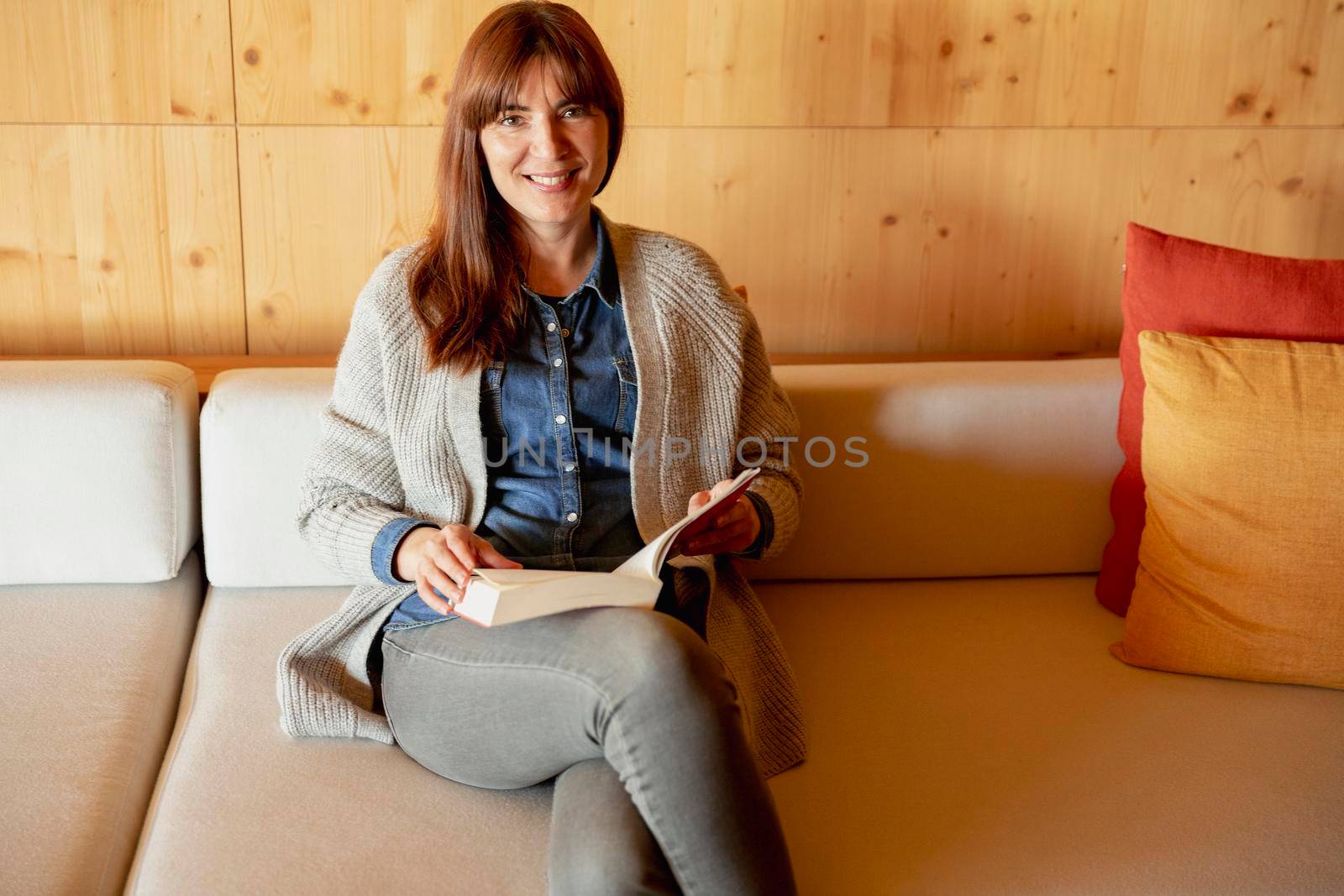 Beautiful woman reading a book on a cozy space