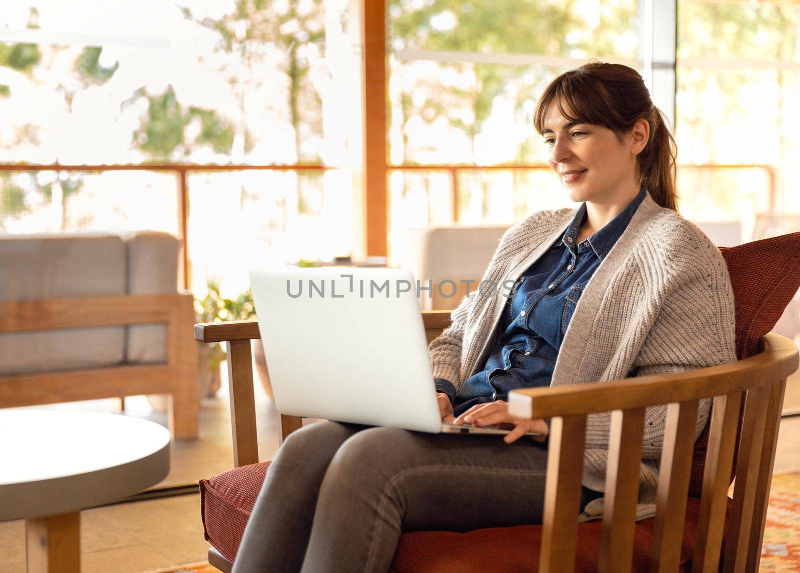 Woman working on a laptop on a cozy space