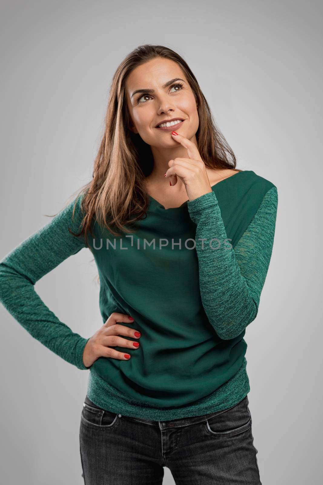 Beautiful woman smiling and with her hand on the chin thinking on something