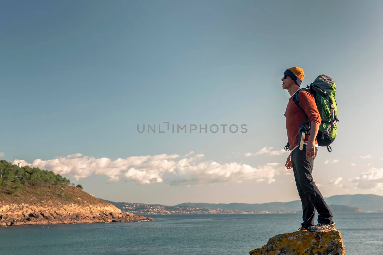 Shot of a man exploring the coastline with backpack