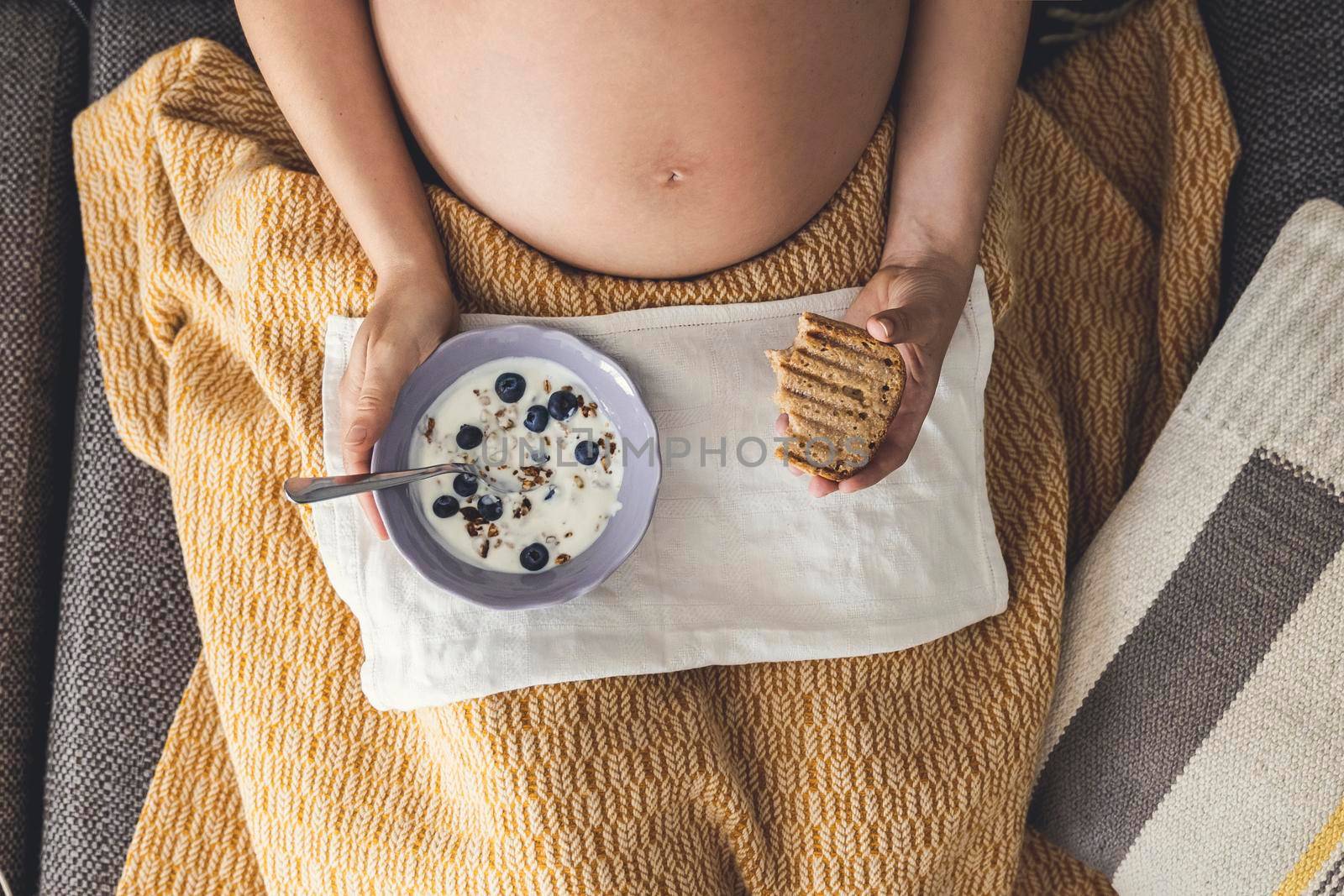 Pregnant woman eating healthy food at home